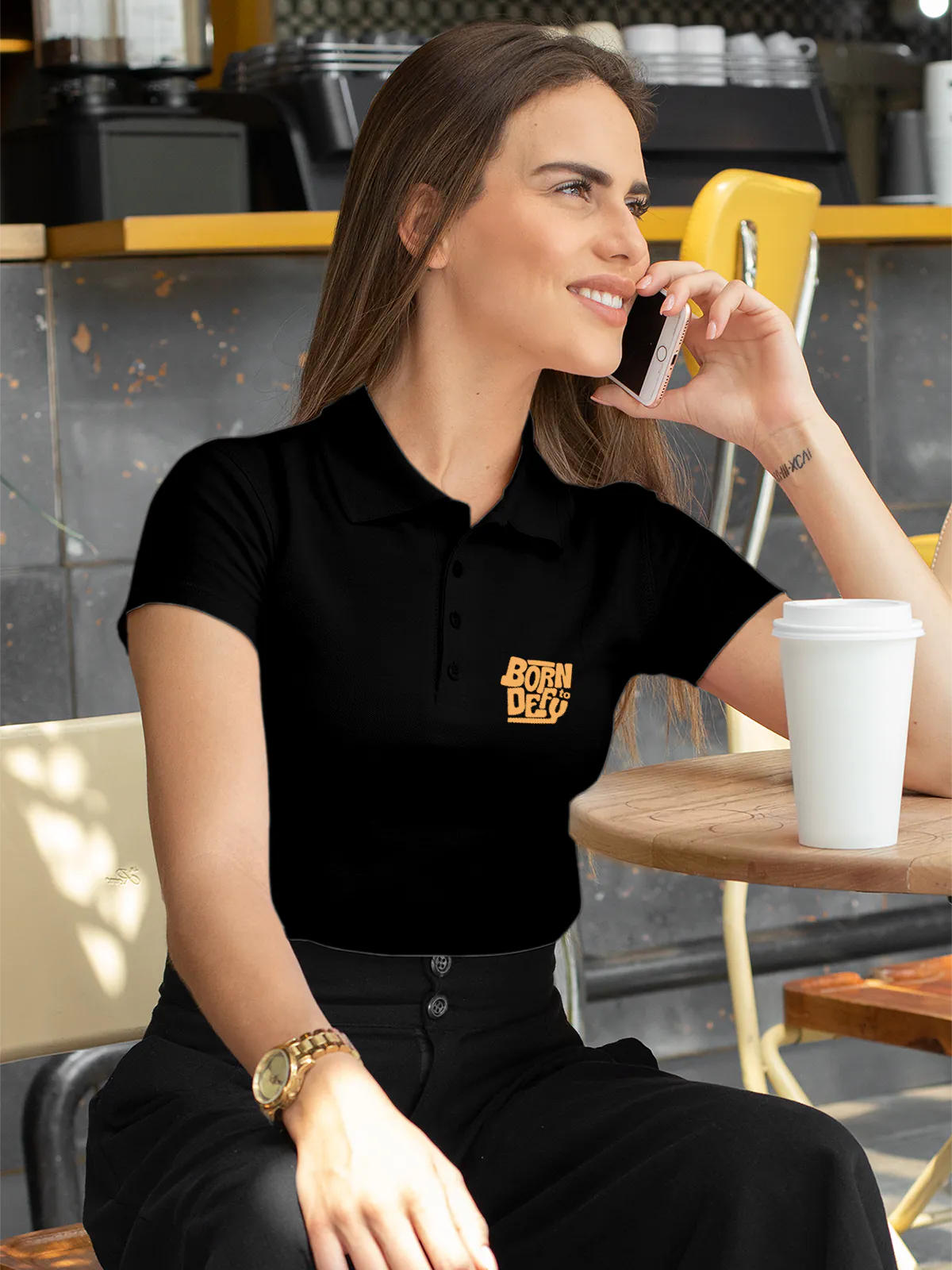 Model wearing Women's Black Polo T-shirt with 'Born To Defy' design, offering effortless style and premium comfort