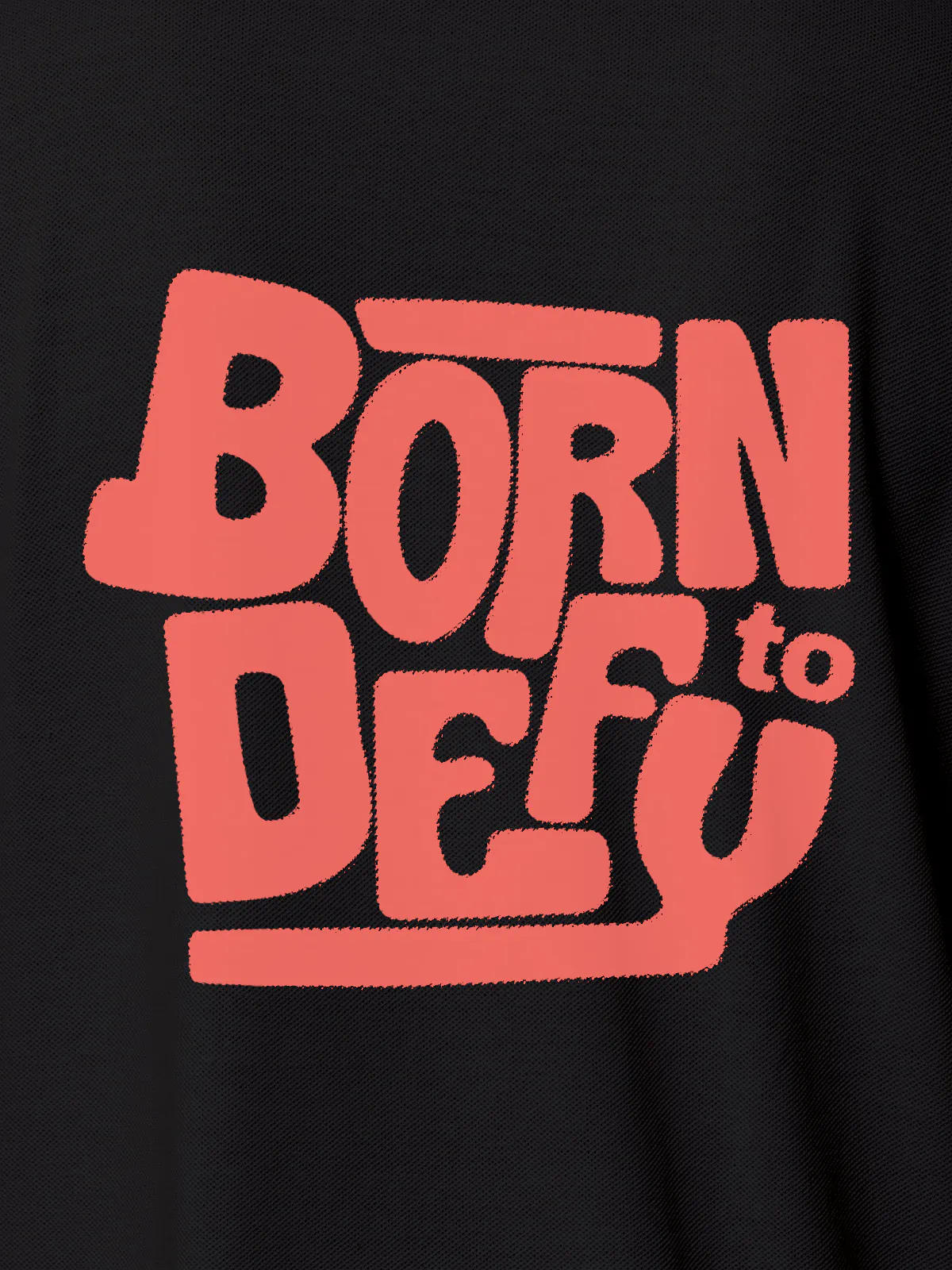 Close up of 'Born To Defy' design on Women's Dark Grey Polo T-shirt, highlighting intricate details and vibrant print.