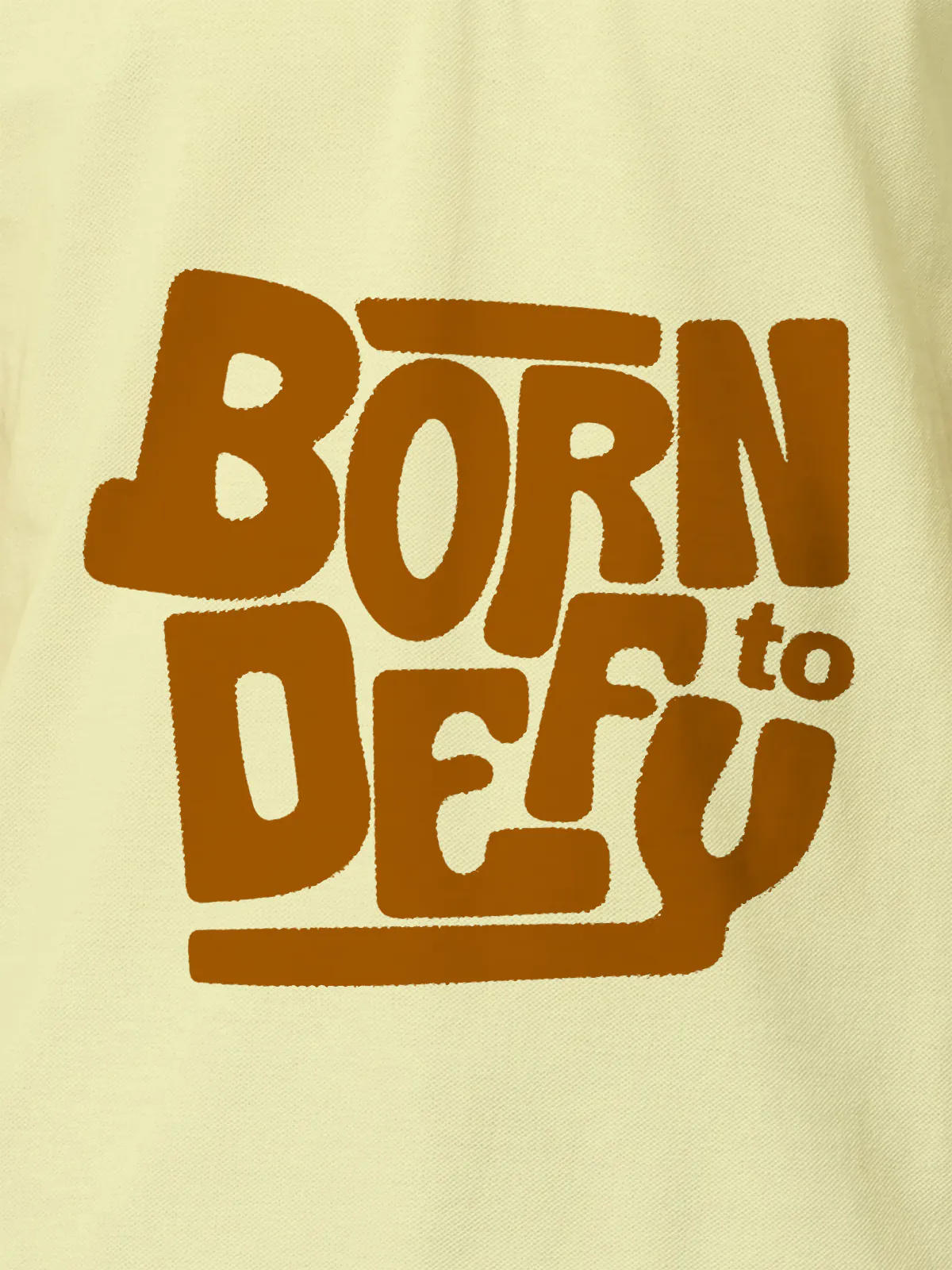 Close up of 'Born To Defy' design on Men's Yellow Polo T-shirt, highlighting intricate details and vibrant print.