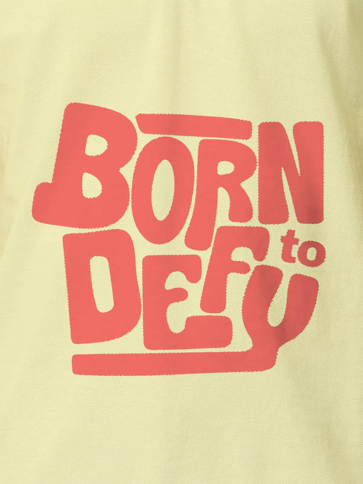 Close up of 'Born To Defy' design on Men's Yellow Polo T-shirt, highlighting intricate details and vibrant print.