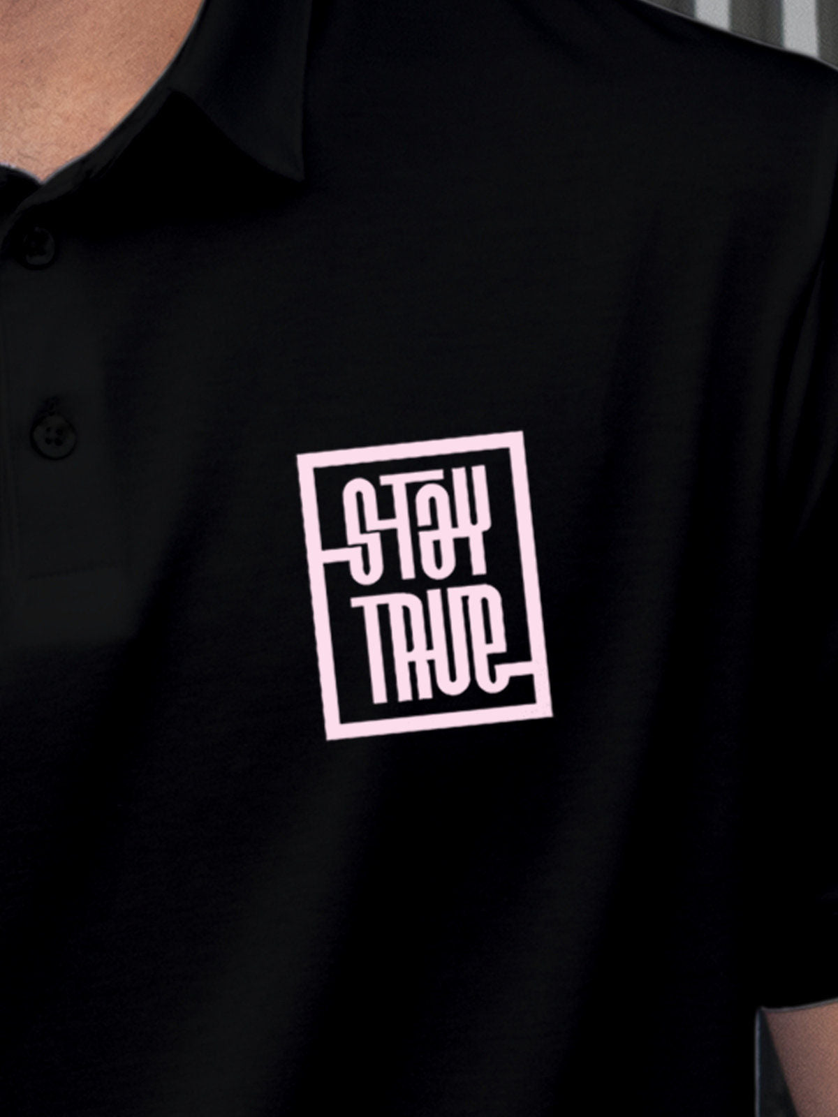 Close up of 'Stay True' design on Men's Black Polo T-shirt, highlighting intricate details and vibrant print.