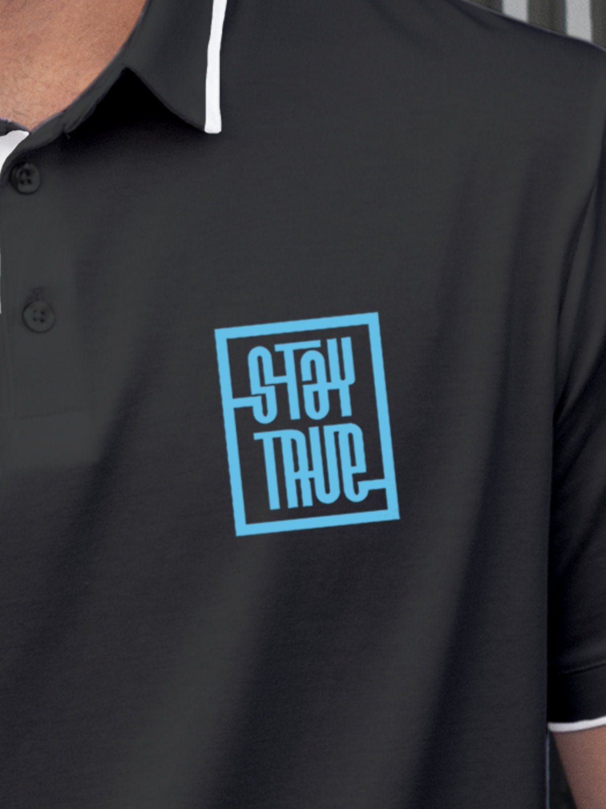 Close up of 'Stay True' on Men's Dark Grey Polo T-shirt, highlighting intricate details and vibrant print.