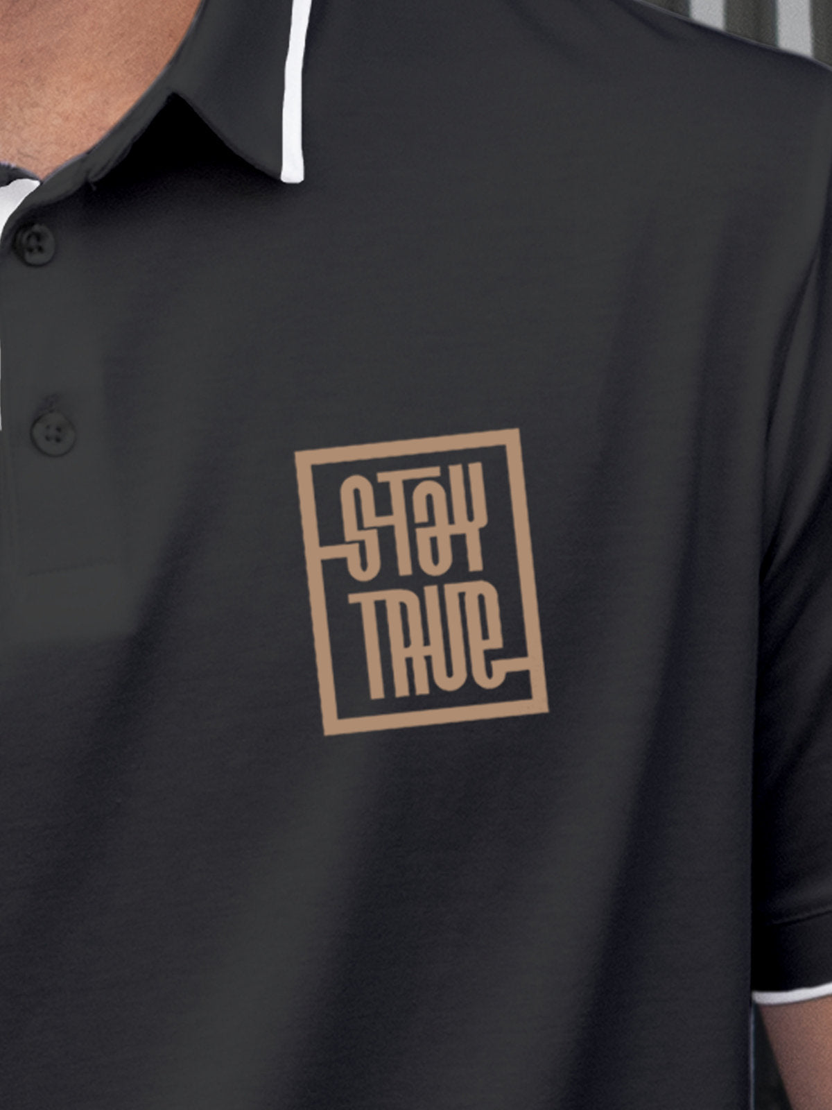 Close up of 'Stay True' on Men's Dark Grey Polo T-shirt, highlighting intricate details and vibrant print.
