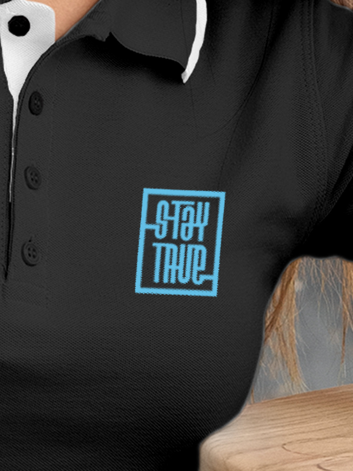 Close up of 'Stay True' on Women's Dark Grey Polo T-shirt, highlighting intricate details and vibrant print.
