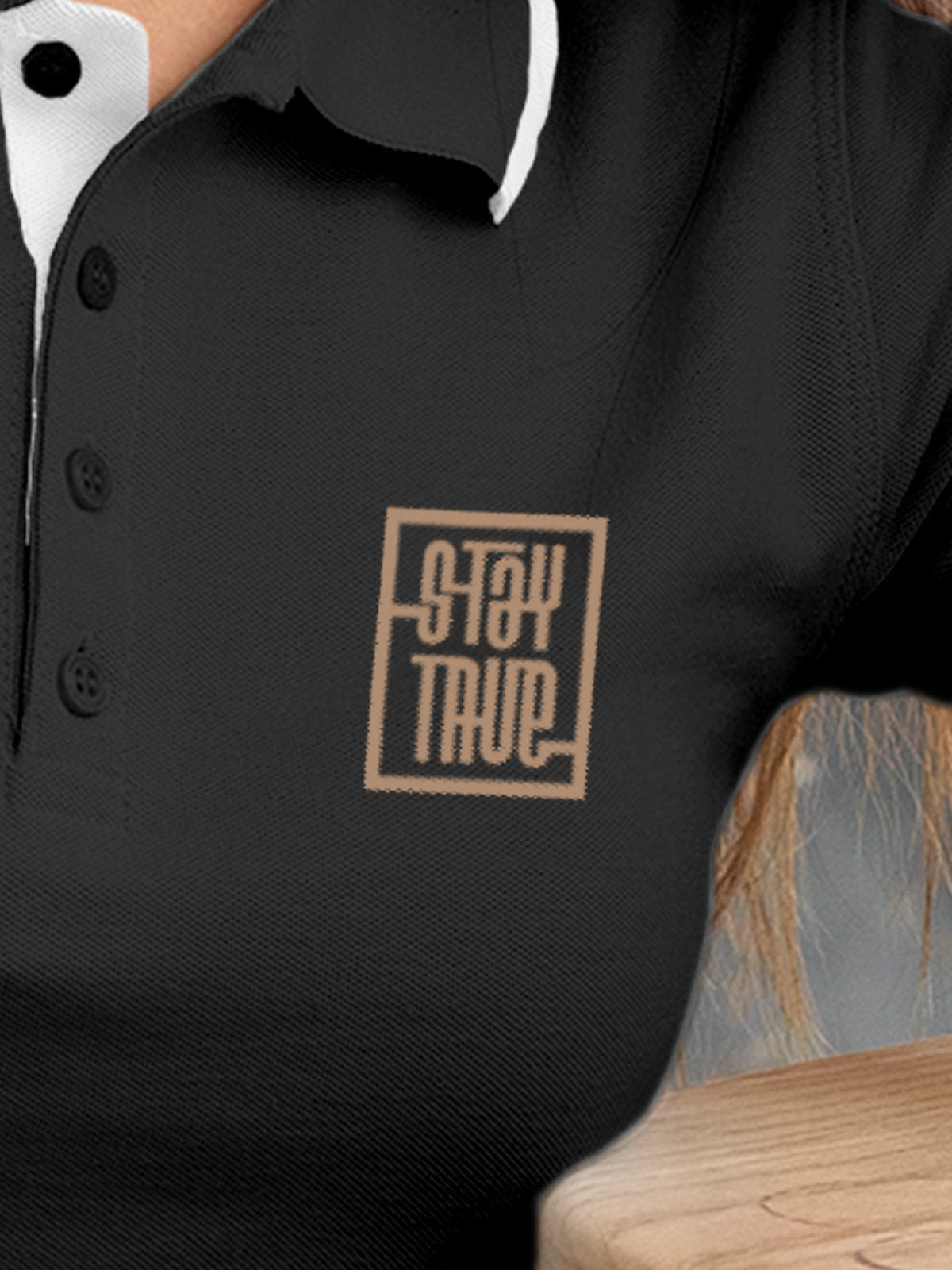 Close up of 'Stay True' design on Women's Dark Grey Polo T-shirt, highlighting intricate details and vibrant print.