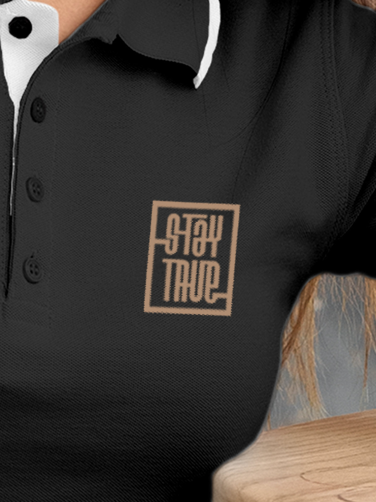 Close up of 'Stay True' on Women's Dark Grey Polo T-shirt, highlighting intricate details and vibrant print.