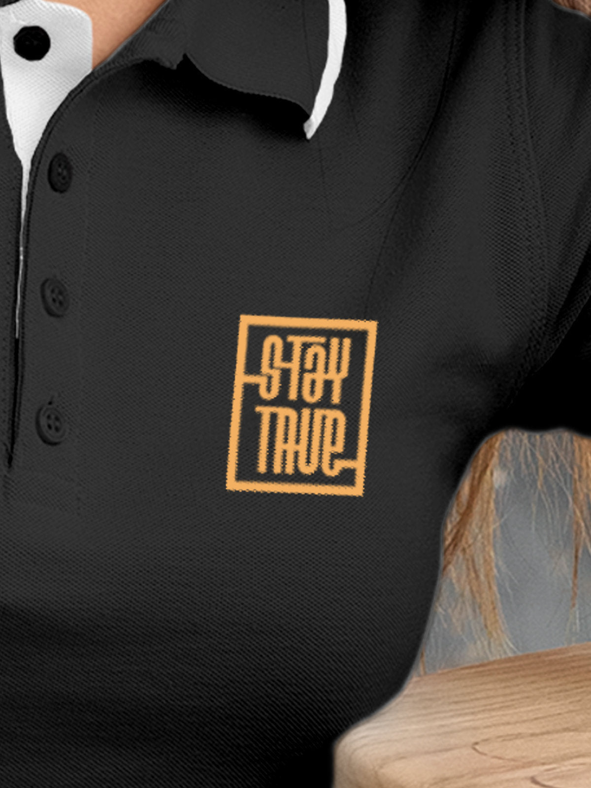 Close up of 'Stay True' on Women's Dark Grey Polo T-shirt, highlighting intricate details and vibrant print.