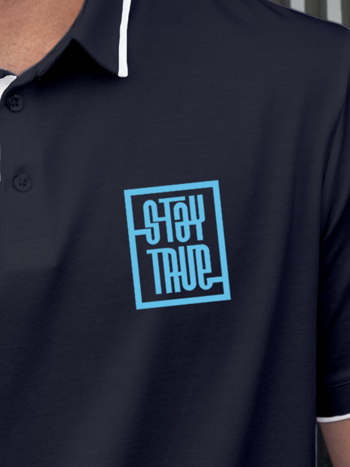 Close up of 'Stay True' on Men's Navy Blue Polo T-shirt, highlighting intricate details and vibrant print.