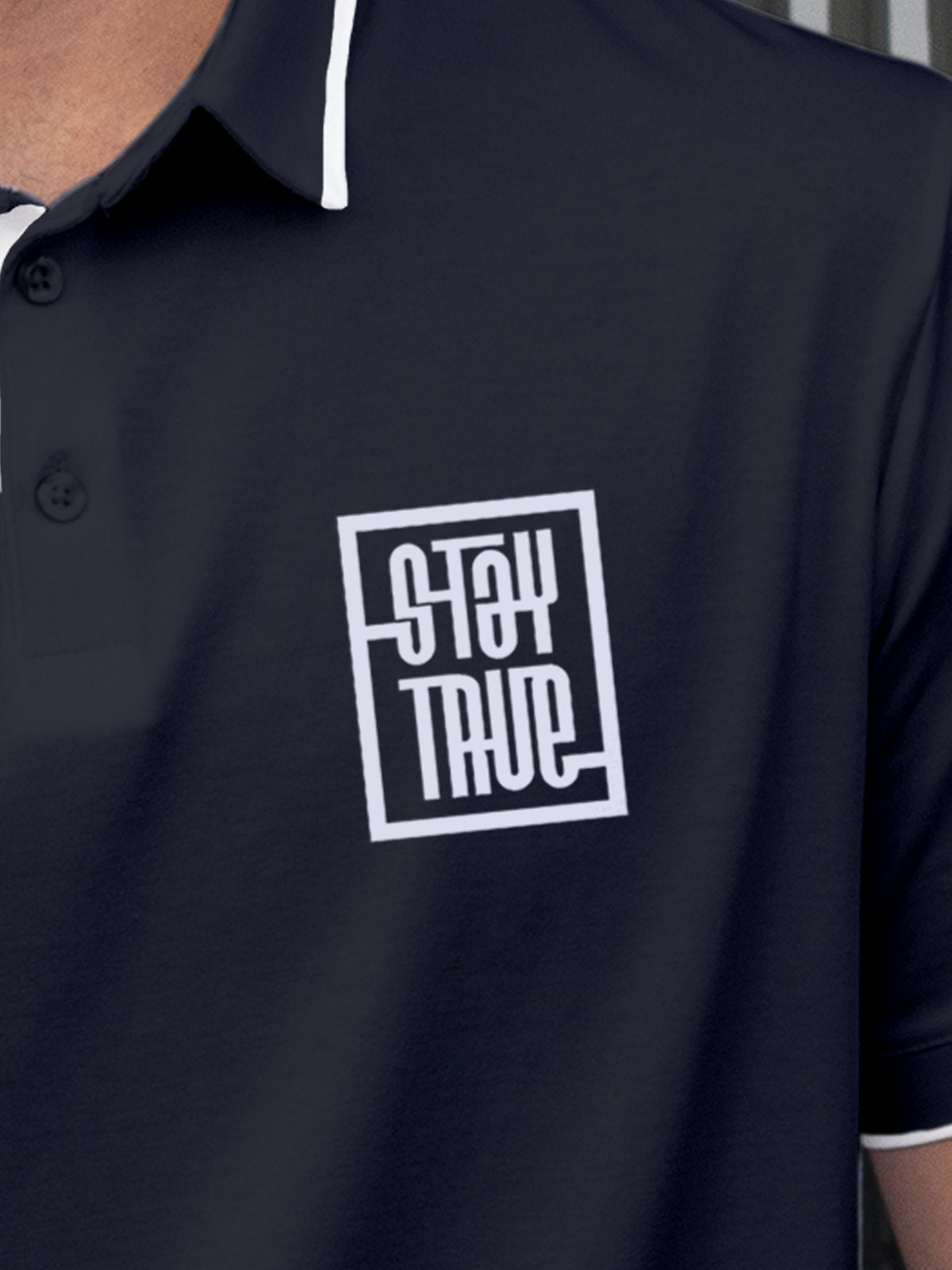 Close up of 'Stay True' on Men's Navy Blue Polo T-shirt, highlighting intricate details and vibrant print.