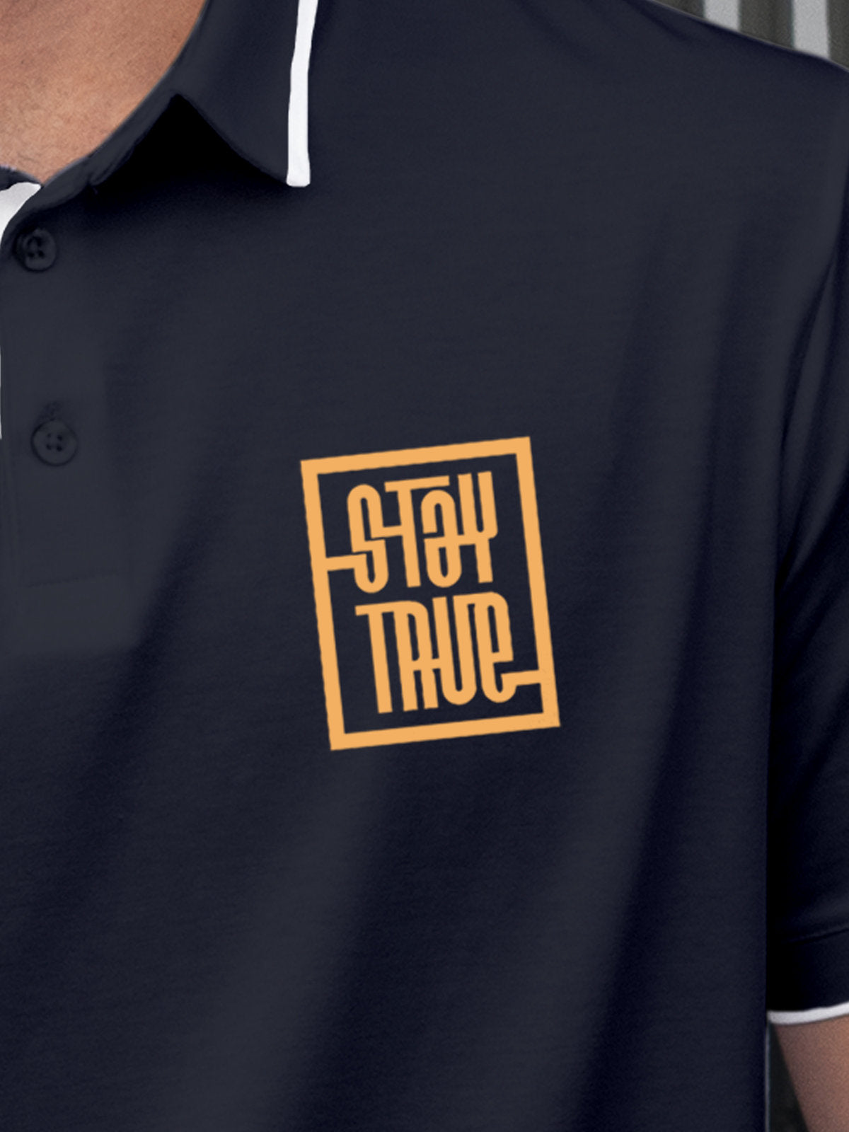 Close up of 'Stay True' on Men's Navy Blue Polo T-shirt, highlighting intricate details and vibrant print.