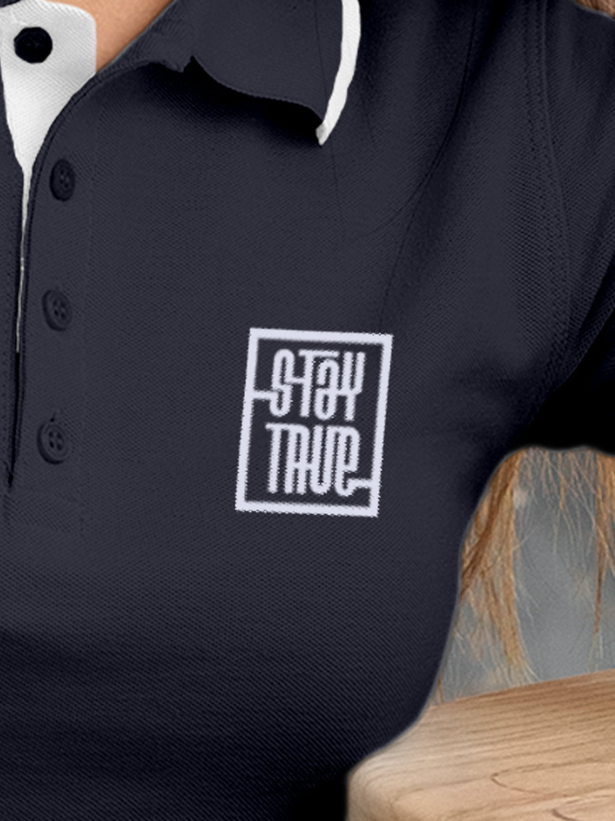 Close up of 'Stay True' on Women's Navy Blue Polo T-shirt, highlighting intricate details and vibrant print.