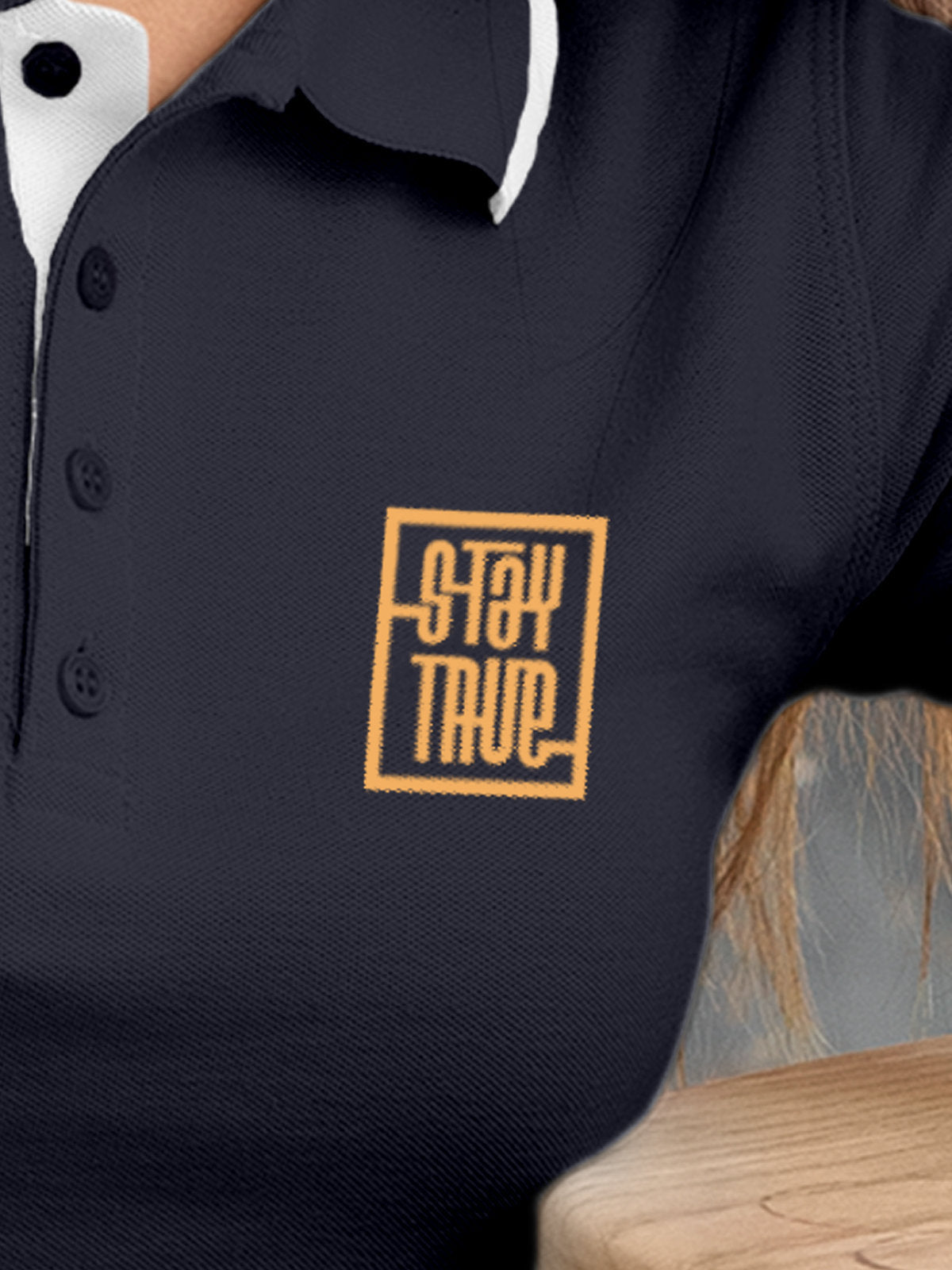 Close up of 'Stay True' on Women's Navy Blue Polo T-shirt, highlighting intricate details and vibrant print.