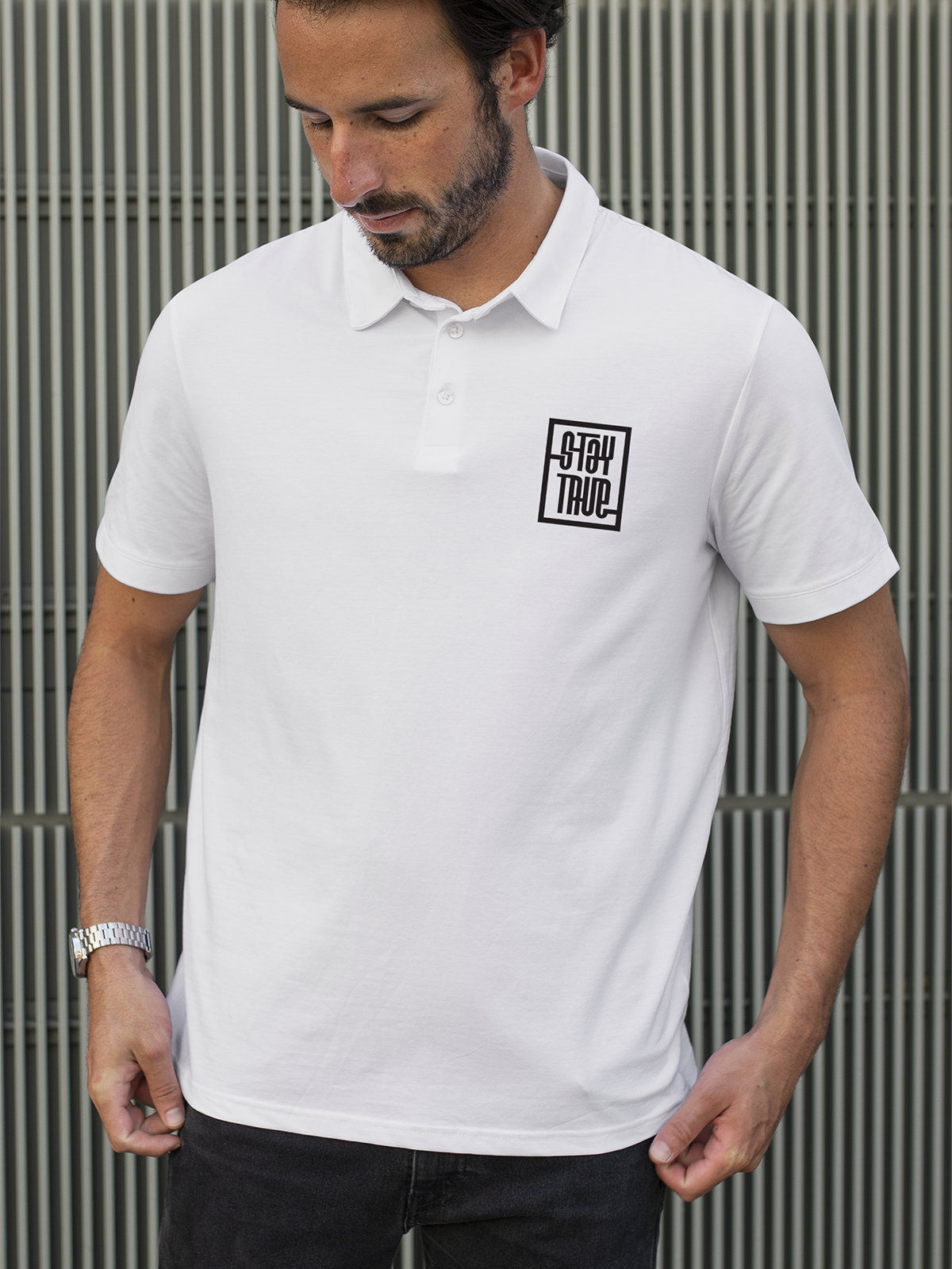 Model wearing Men's White Polo T-shirt with 'Stay True' design, offering effortless style and premium comfort