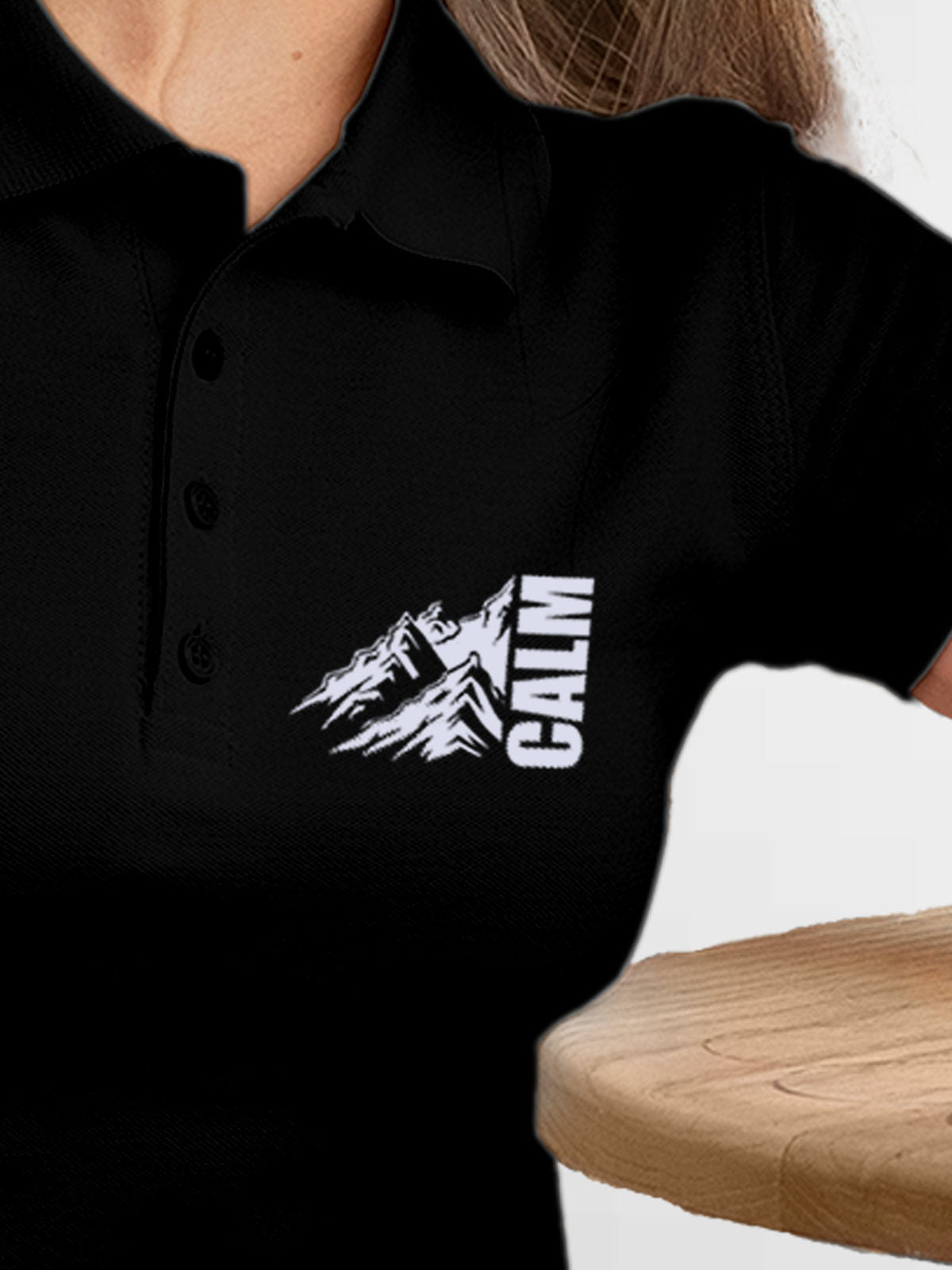 Close up of 'Calm' design on Women's Black Polo T-shirt, highlighting intricate details and vibrant print.