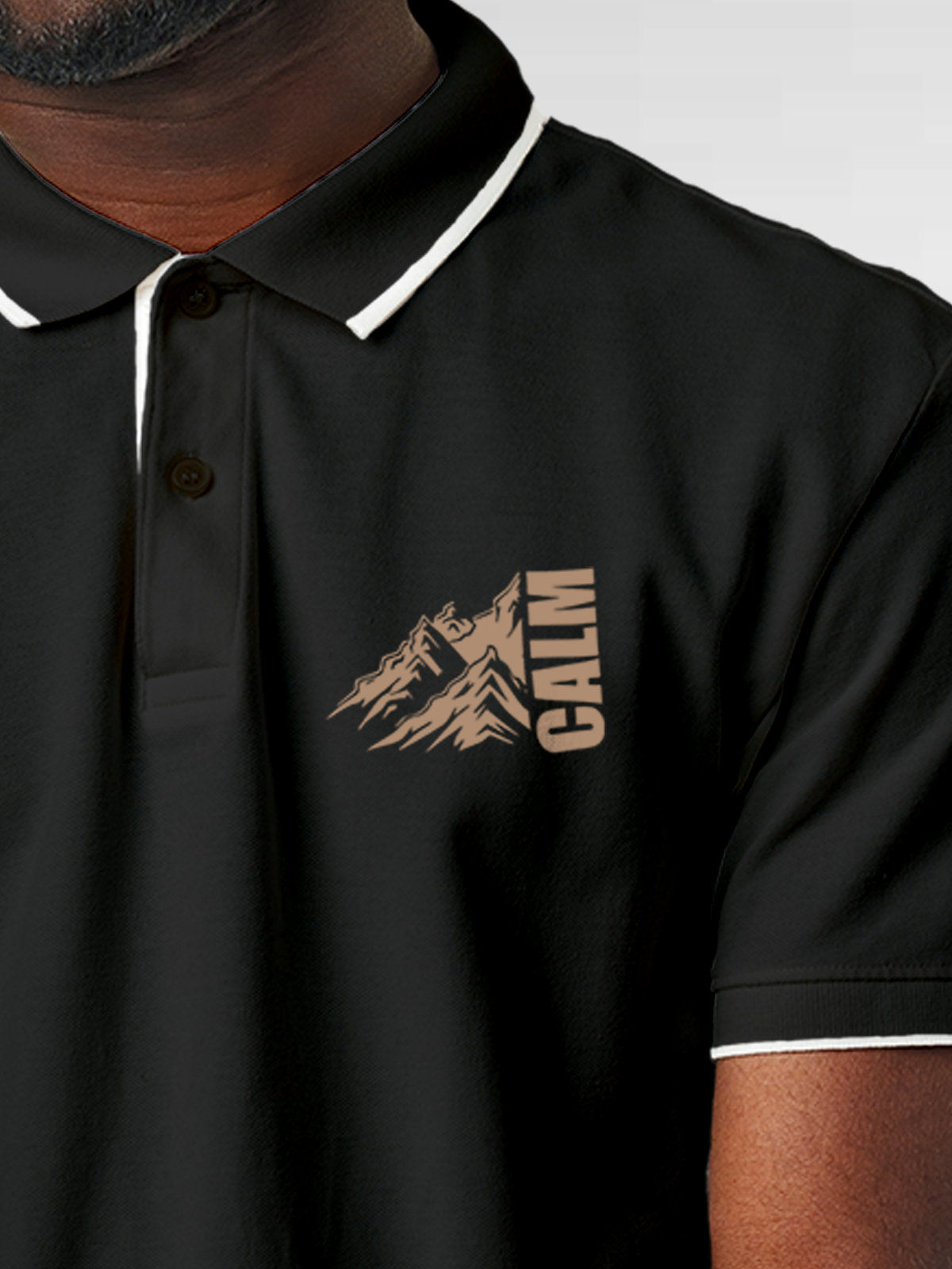 Close up of 'Calm' design on Men's Dark Grey Polo T-shirt, highlighting intricate details and vibrant print.