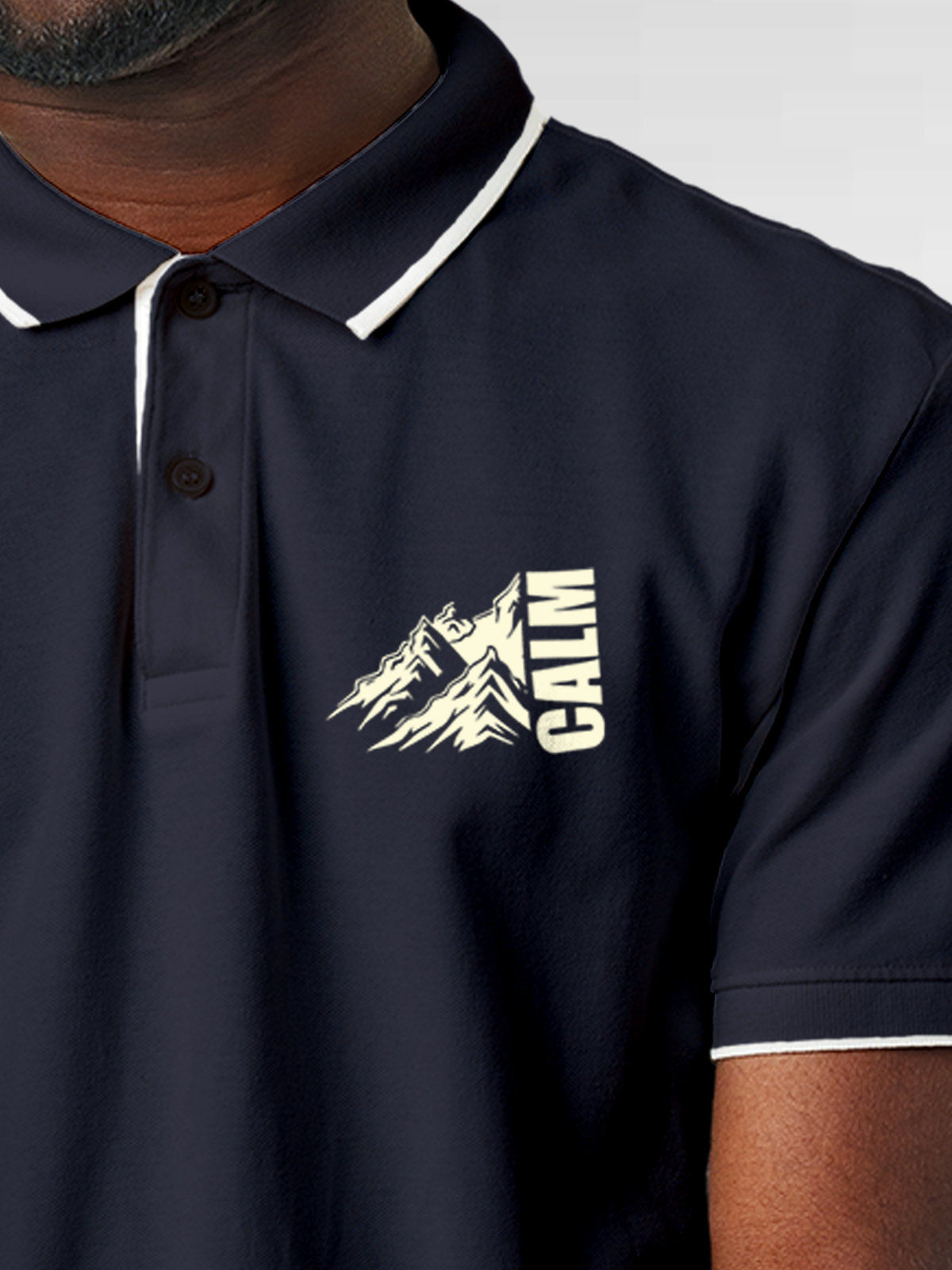 Close up of 'Calm' design on Men's Navy Blue Polo T-shirt, highlighting intricate details and vibrant print.