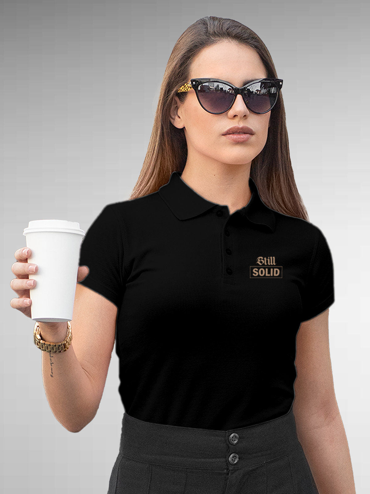 Model wearing Women's Black Polo T-shirt with 'Still Solid' design, offering effortless style and premium comfort