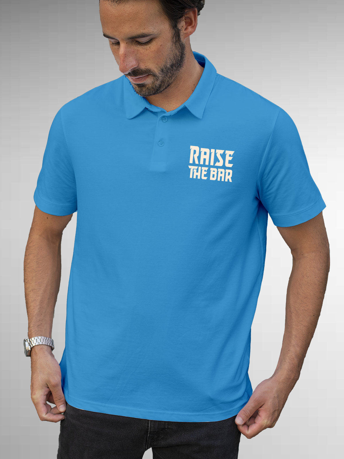 Model wearing Men's Blue Polo T-shirt with 'Raise The Bar' design, offering effortless style and premium comfort