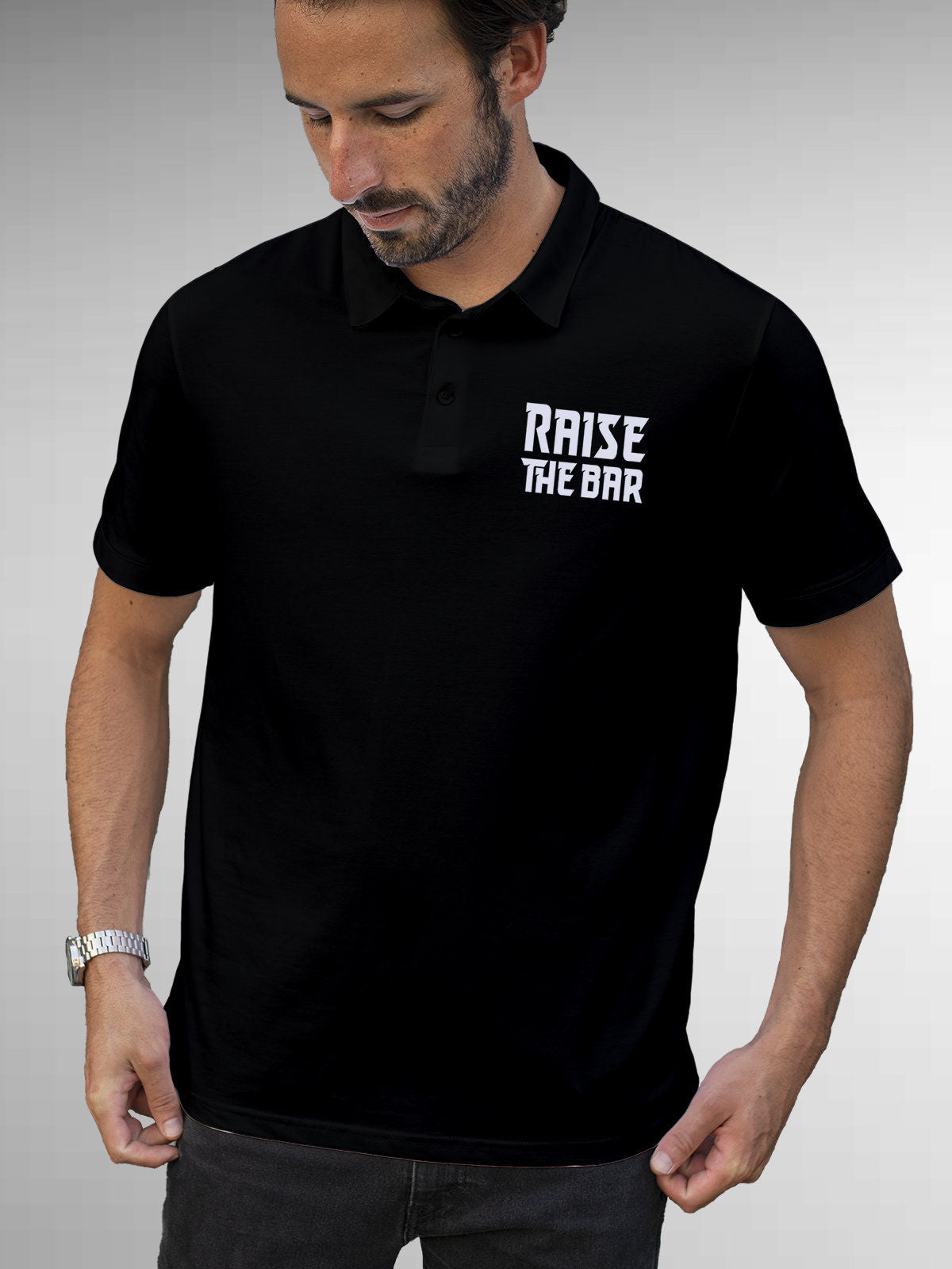 Model wearing Men's Black Polo T-shirt with 'Raise The Bar' design, offering effortless style and premium comfort