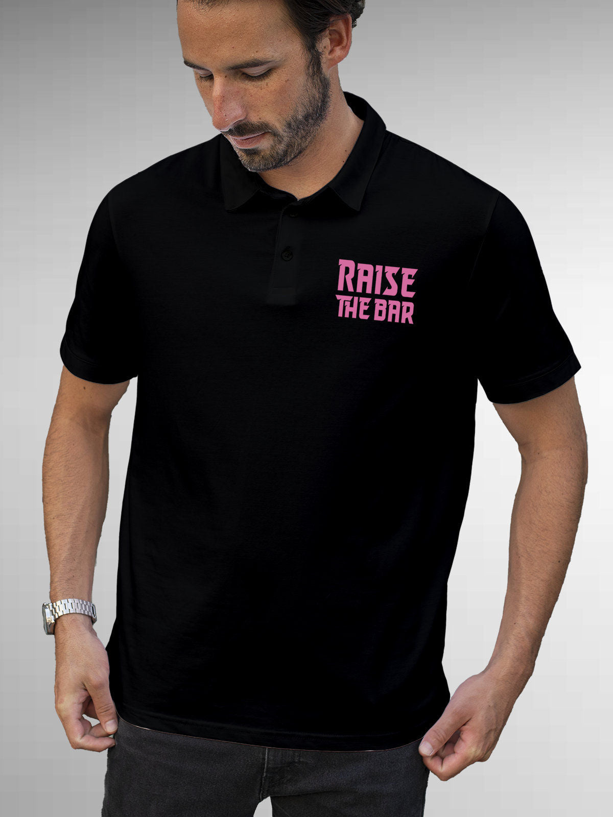 Model wearing Men's Black Polo T-shirt with 'Raise The Bar' design, offering effortless style and premium comfort