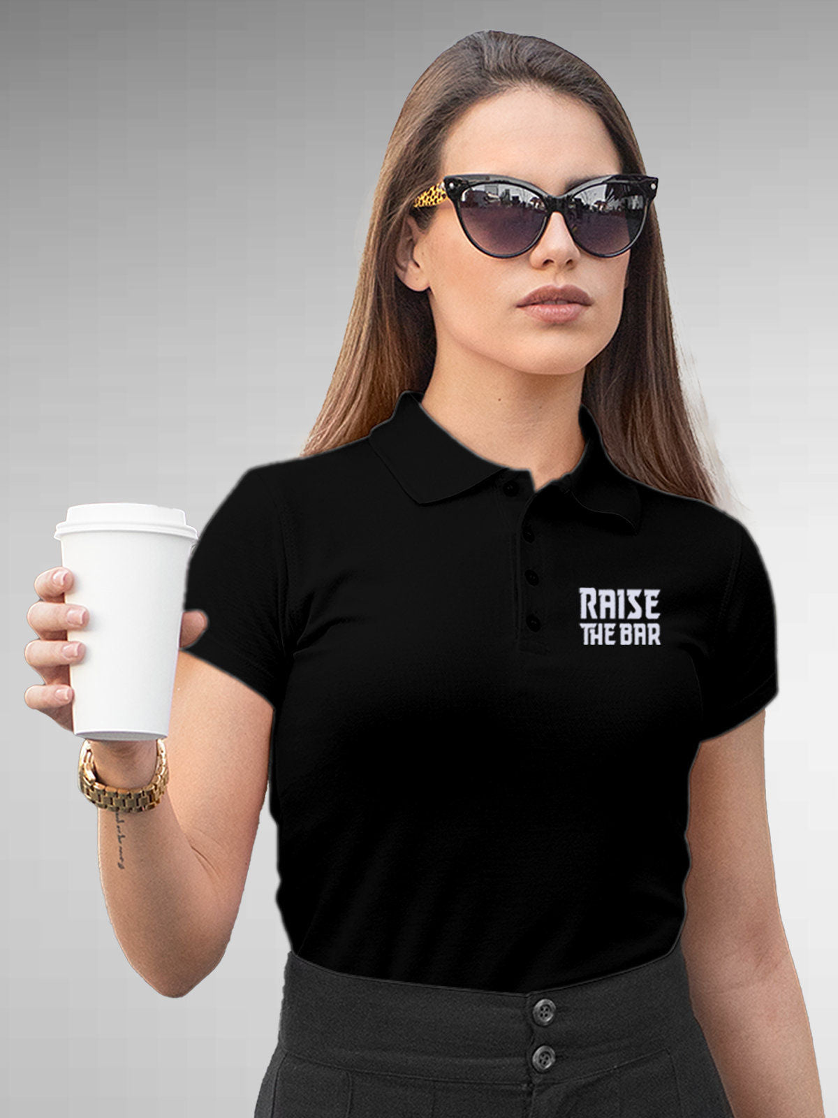 Model wearing Women's Black Polo T-shirt with 'Raise The Bar' design, offering effortless style and premium comfort