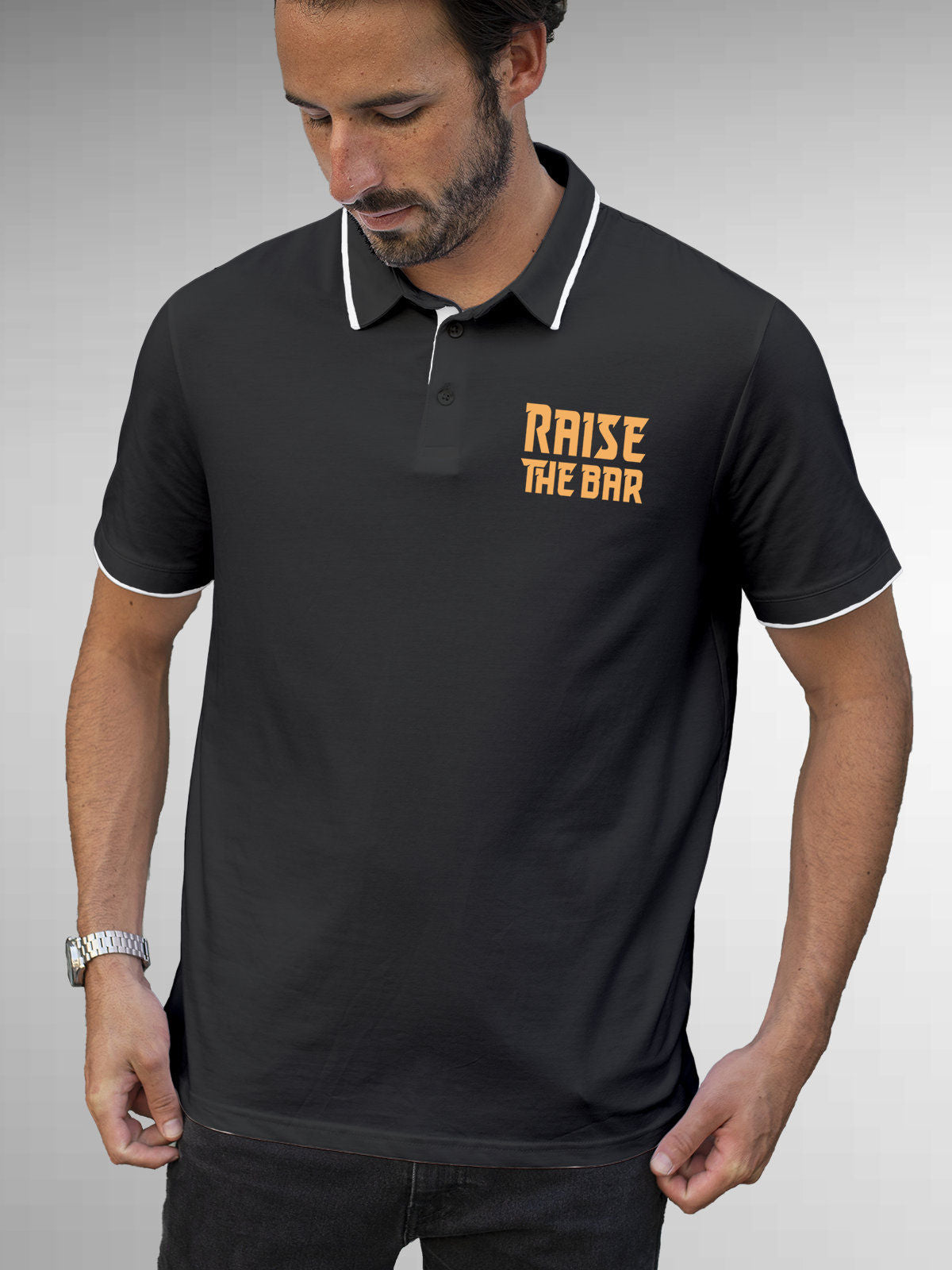 Model wearing Men's Dark Grey Polo T-shirt with 'Raise The Bar' design, offering effortless style and premium comfort