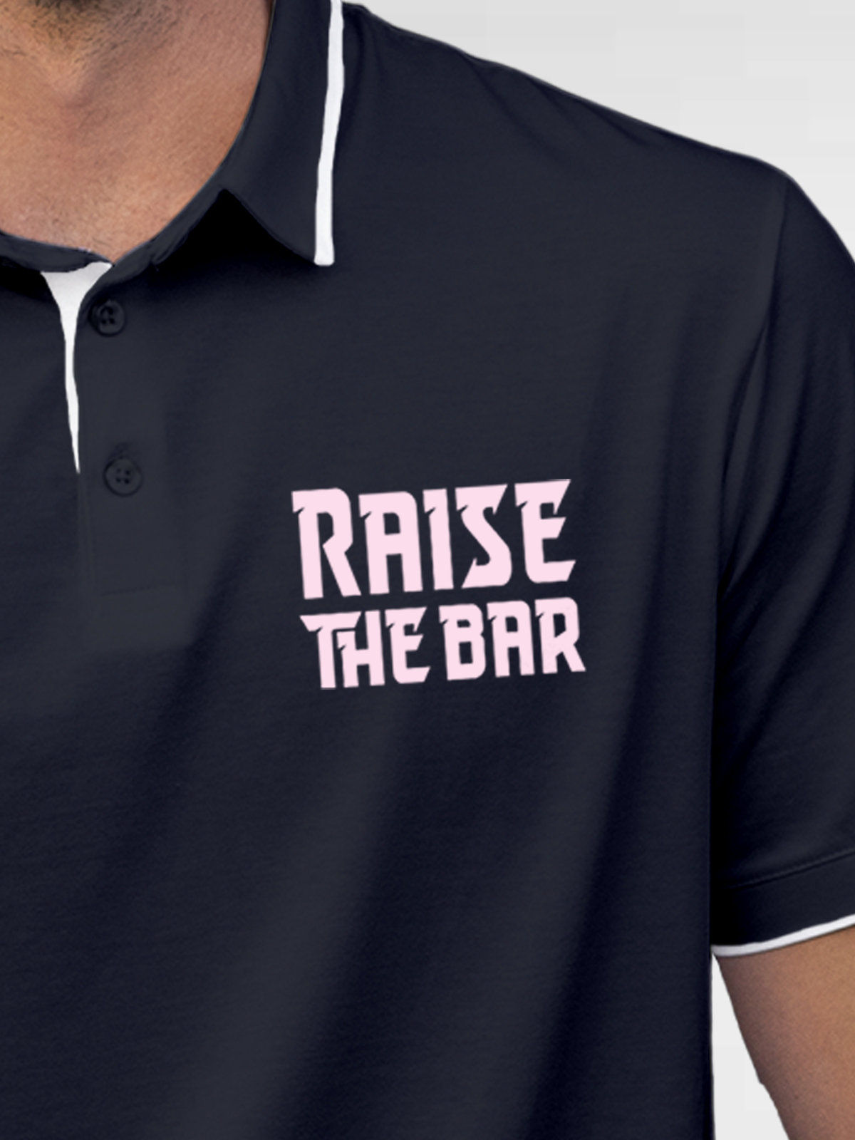 Close up of 'Raise The Bar' design on Men's Navy Blue Polo T-shirt, highlighting intricate details and vibrant print.
