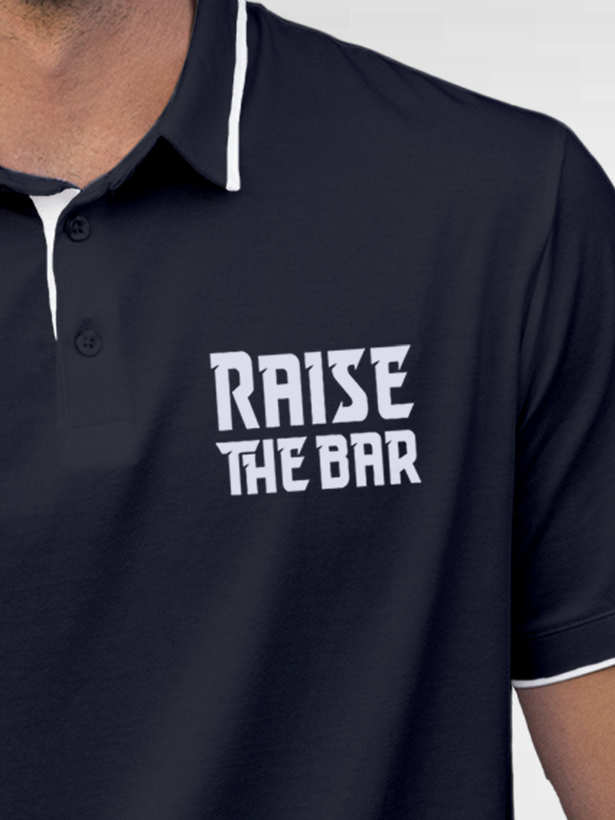 Close up of 'Raise The Bar' design on Men's Navy Blue Polo T-shirt, highlighting intricate details and vibrant print.
