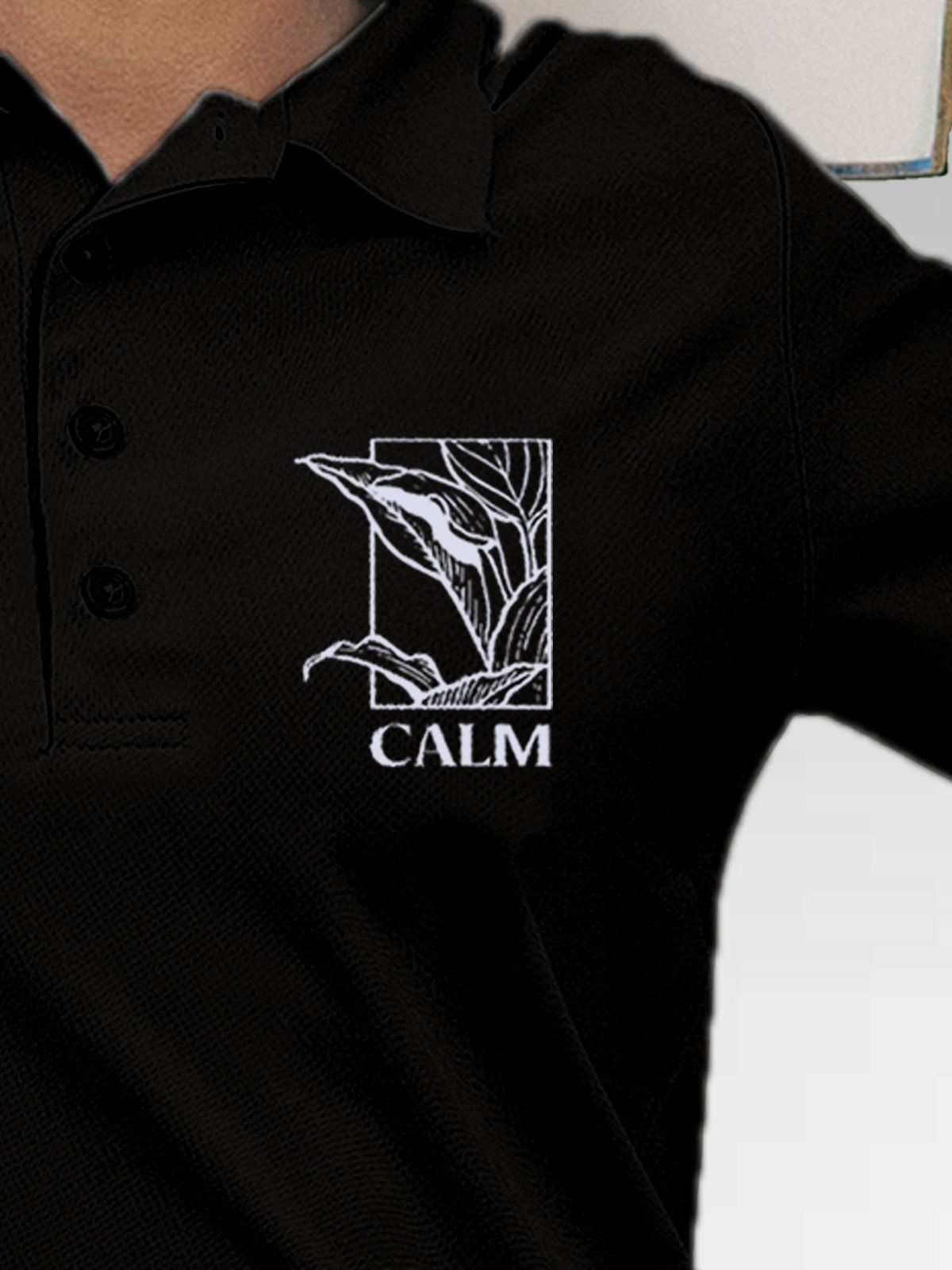 Close up of 'Calm' design on Women's Black Polo T-shirt, highlighting intricate details and vibrant print.