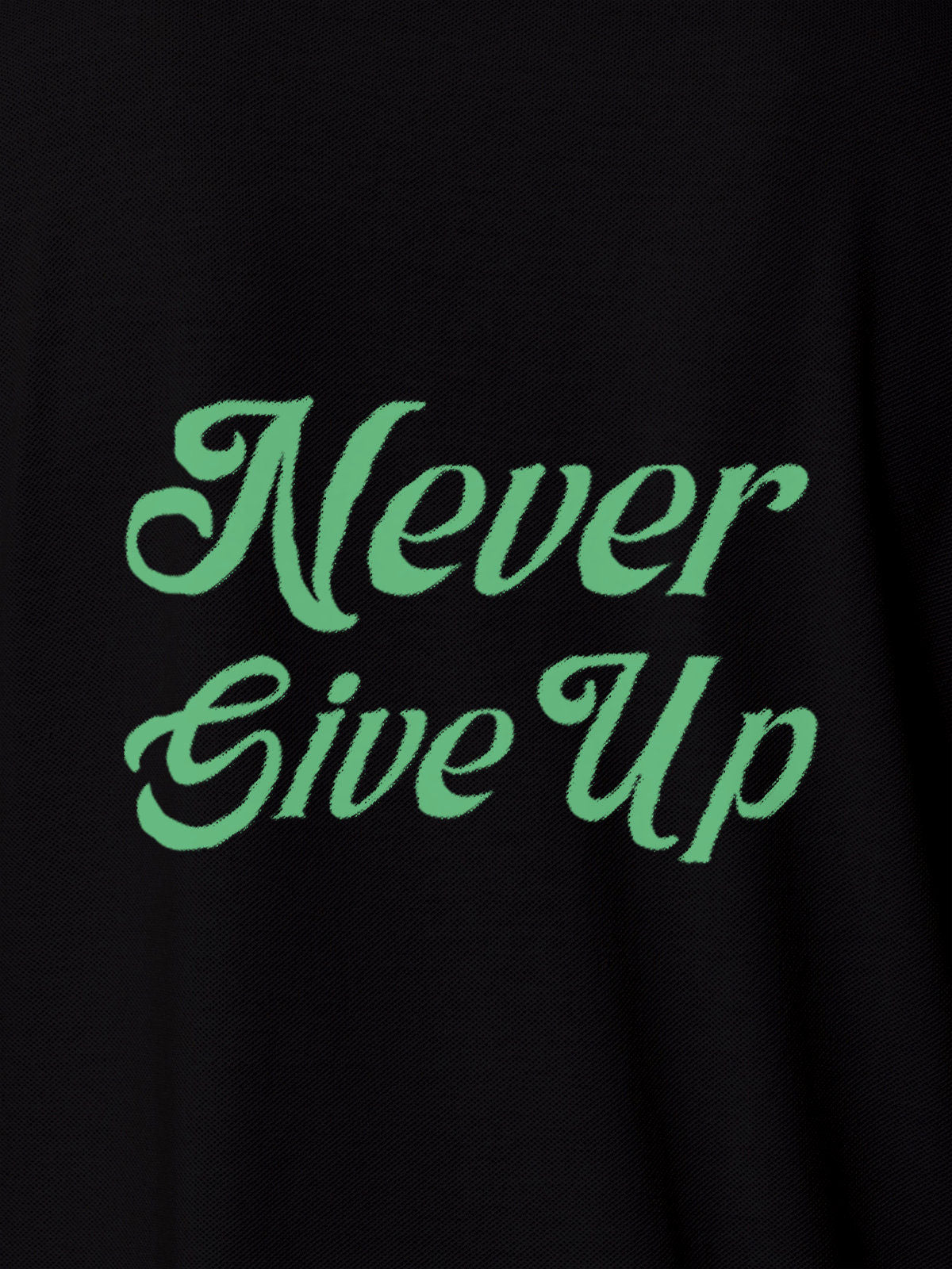 Close up of 'Never Give Up' design on Women's Black Polo T-shirt, highlighting intricate details and vibrant print.