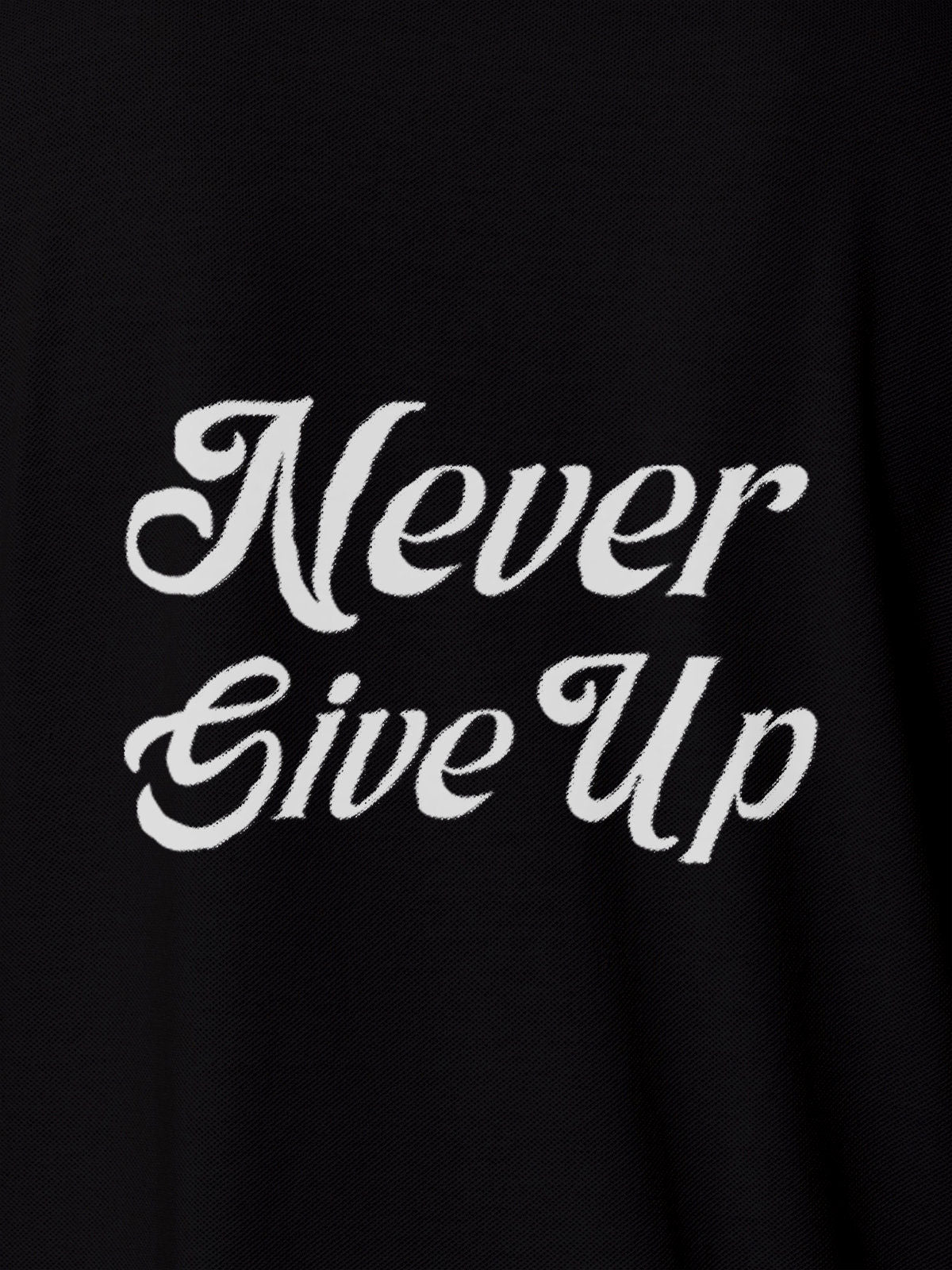 Close up of 'Never Give Up' design on Women's Black Polo T-shirt, highlighting intricate details and vibrant print.