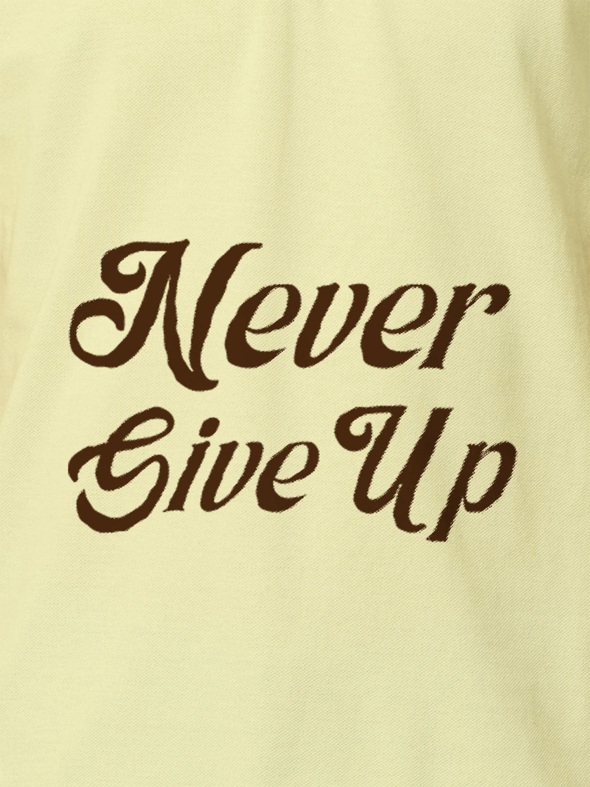 Close up of 'Never Give Up' design on Men's Yellow Polo T-shirt, highlighting intricate details and vibrant print.