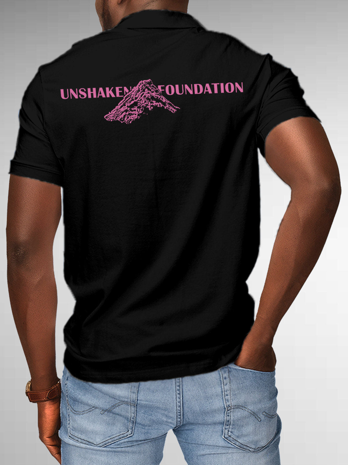 Model wearing Men's Black Polo T-shirt with 'Unshaken Foundation' design, offering effortless style and premium comfort