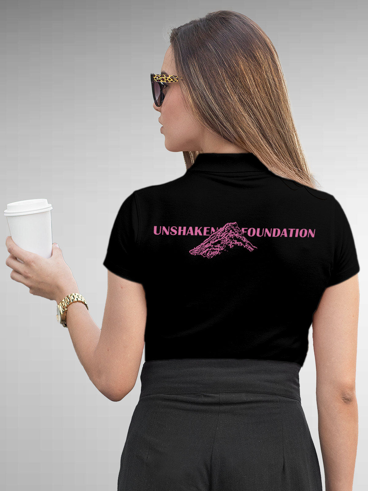 Model wearing Women's Black Polo T-shirt with 'Unshaken Foundation' design, offering effortless style and premium comfort