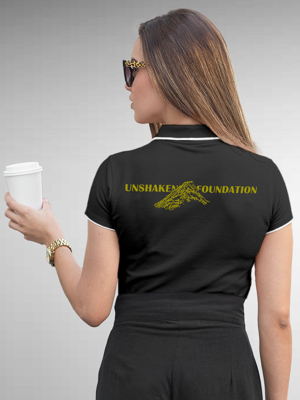 Model wearing Women's Dark Grey Polo T-shirt with 'Unshaken Foundation' design, offering effortless style and premium comfort