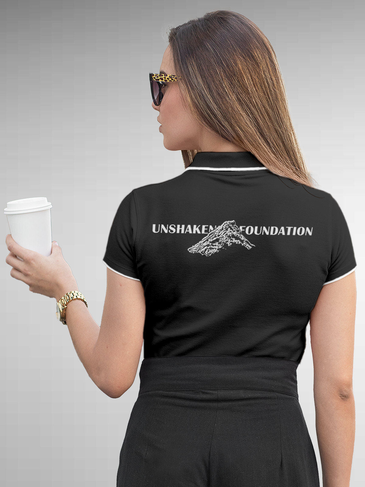 Model wearing Women's Dark Grey Polo T-shirt with 'Unshaken Foundation' design, offering effortless style and premium comfort
