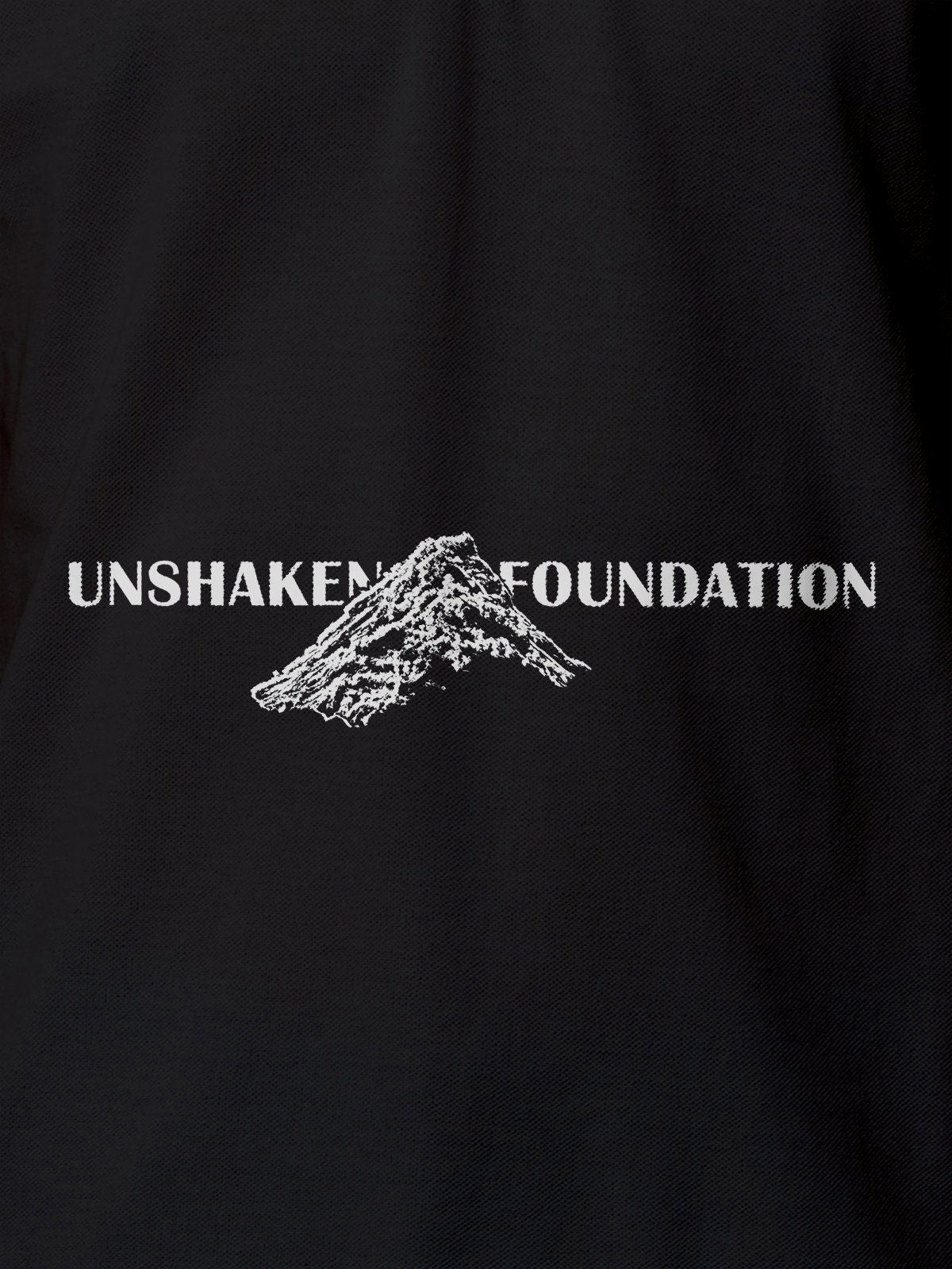 Close up of 'Unshaken Foundation' design on Women's Dark Grey Polo T-shirt, highlighting intricate details and vibrant print.