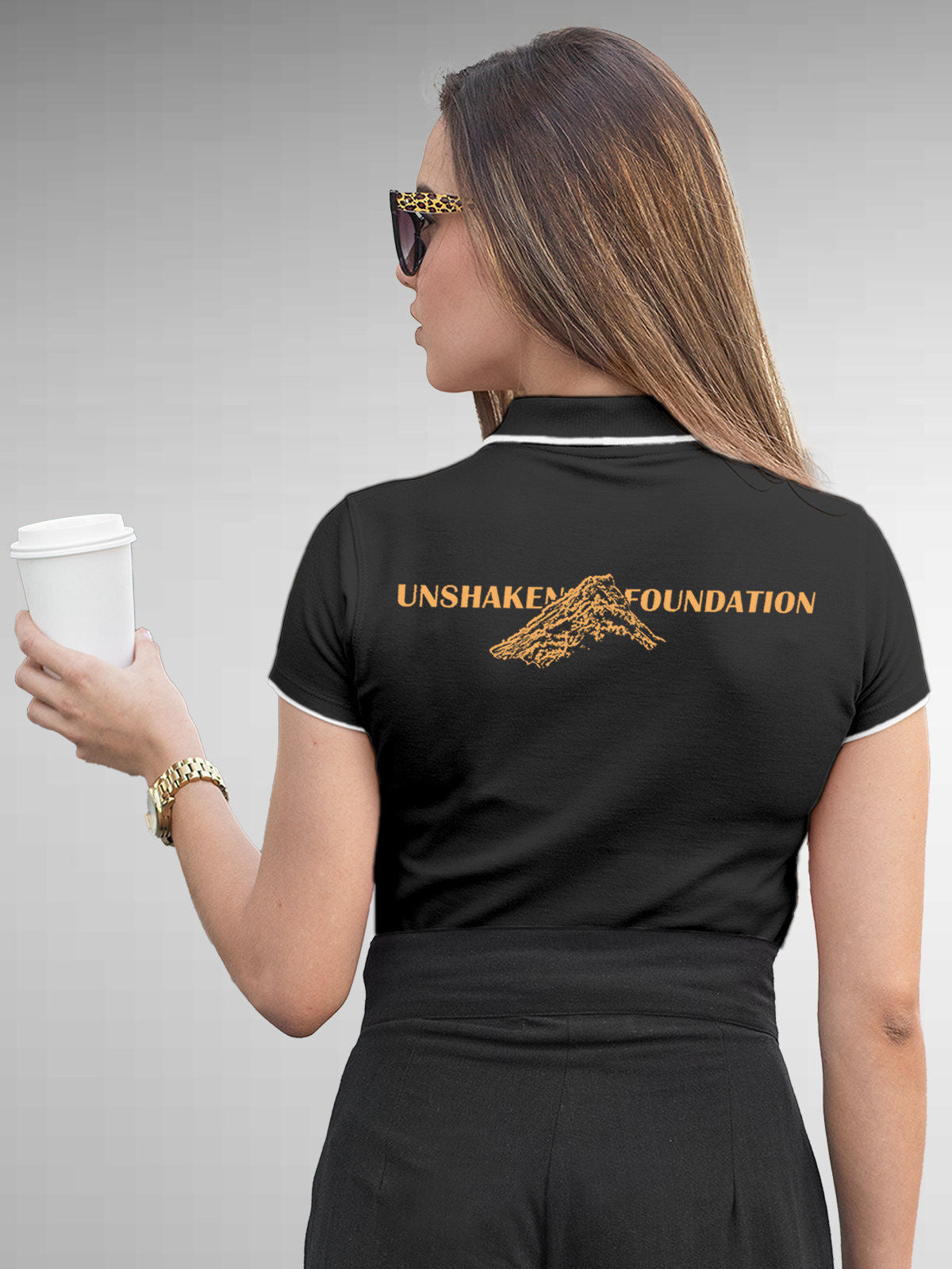 Model wearing Women's Dark Grey Polo T-shirt with 'Unshaken Foundation' design, offering effortless style and premium comfort