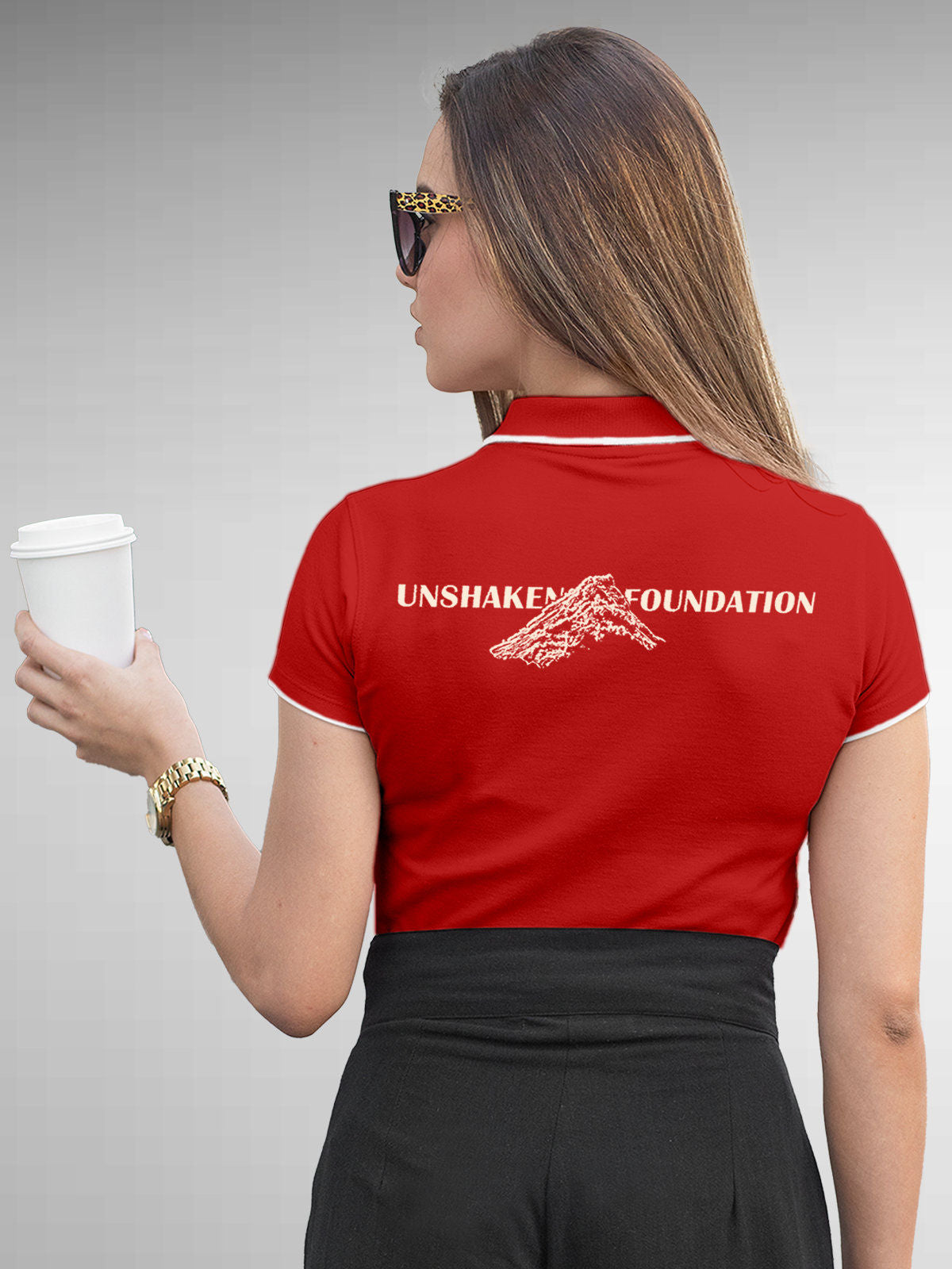 Model wearing Women's Red Polo T-shirt with 'Unshaken Foundation' design, offering effortless style and premium comfort