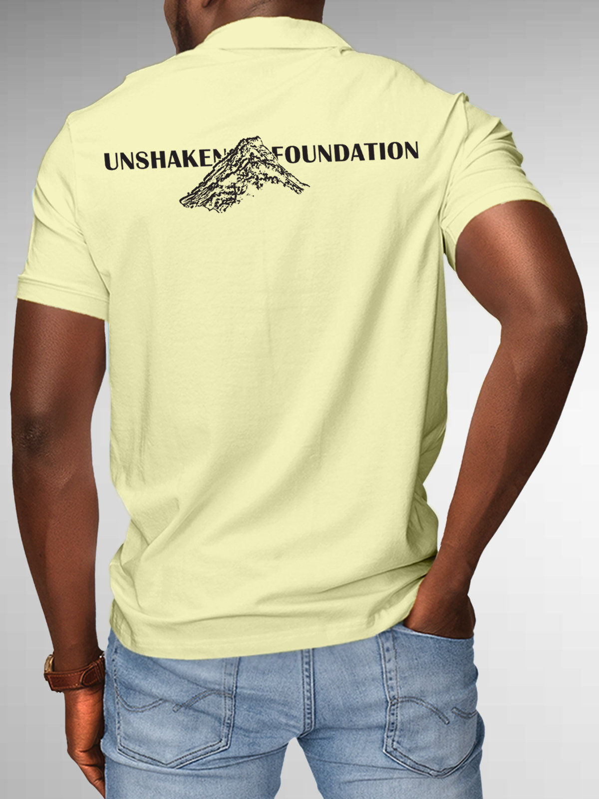 Model wearing Men's Yellow Polo T-shirt with 'Unshaken Foundation' design, offering effortless style and premium comfort