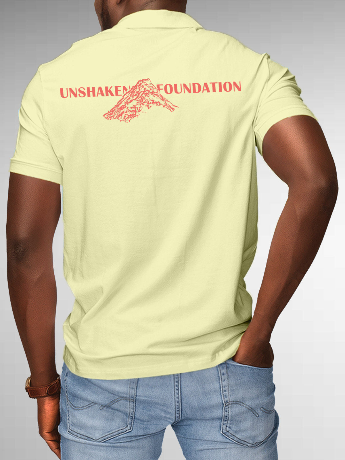 Model wearing Men's Yellow Polo T-shirt with 'Unshaken Foundation' design, offering effortless style and premium comfort