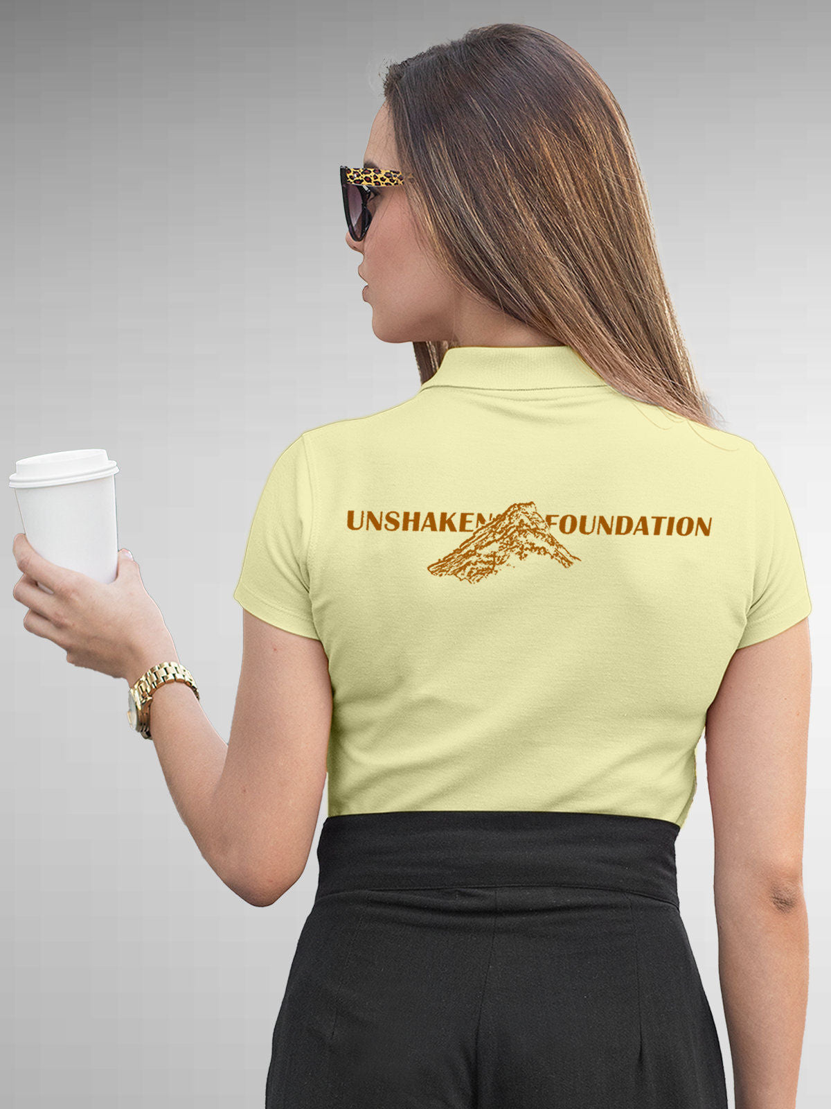 Model wearing Women's Yellow Polo T-shirt with 'Unshaken Foundation' design, offering effortless style and premium comfort