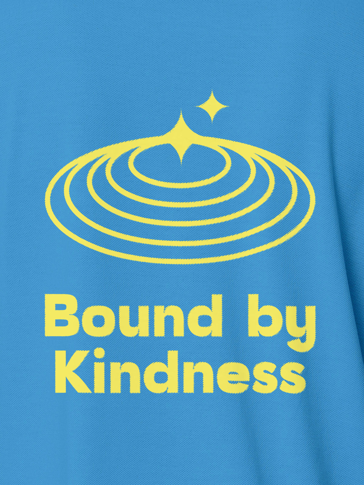 Close up of 'Bound By Kindness' design on Women's Blue Polo T-shirt, highlighting intricate details and vibrant print.