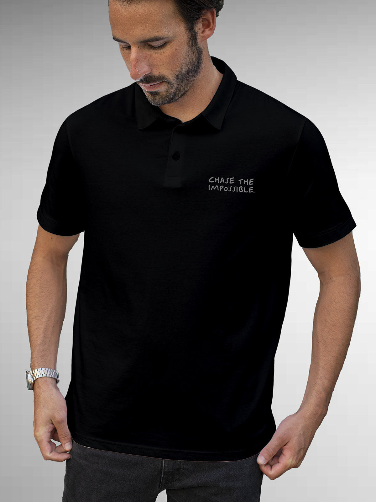 Model wearing Men's Black Polo T-shirt with 'Chase The Impossible' design, offering effortless style and premium comfort