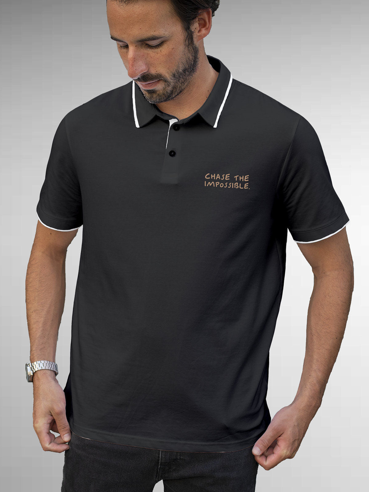 Model wearing Men's Dark Grey Polo T-shirt with 'Chase The Impossible' design, offering effortless style and premium comfort