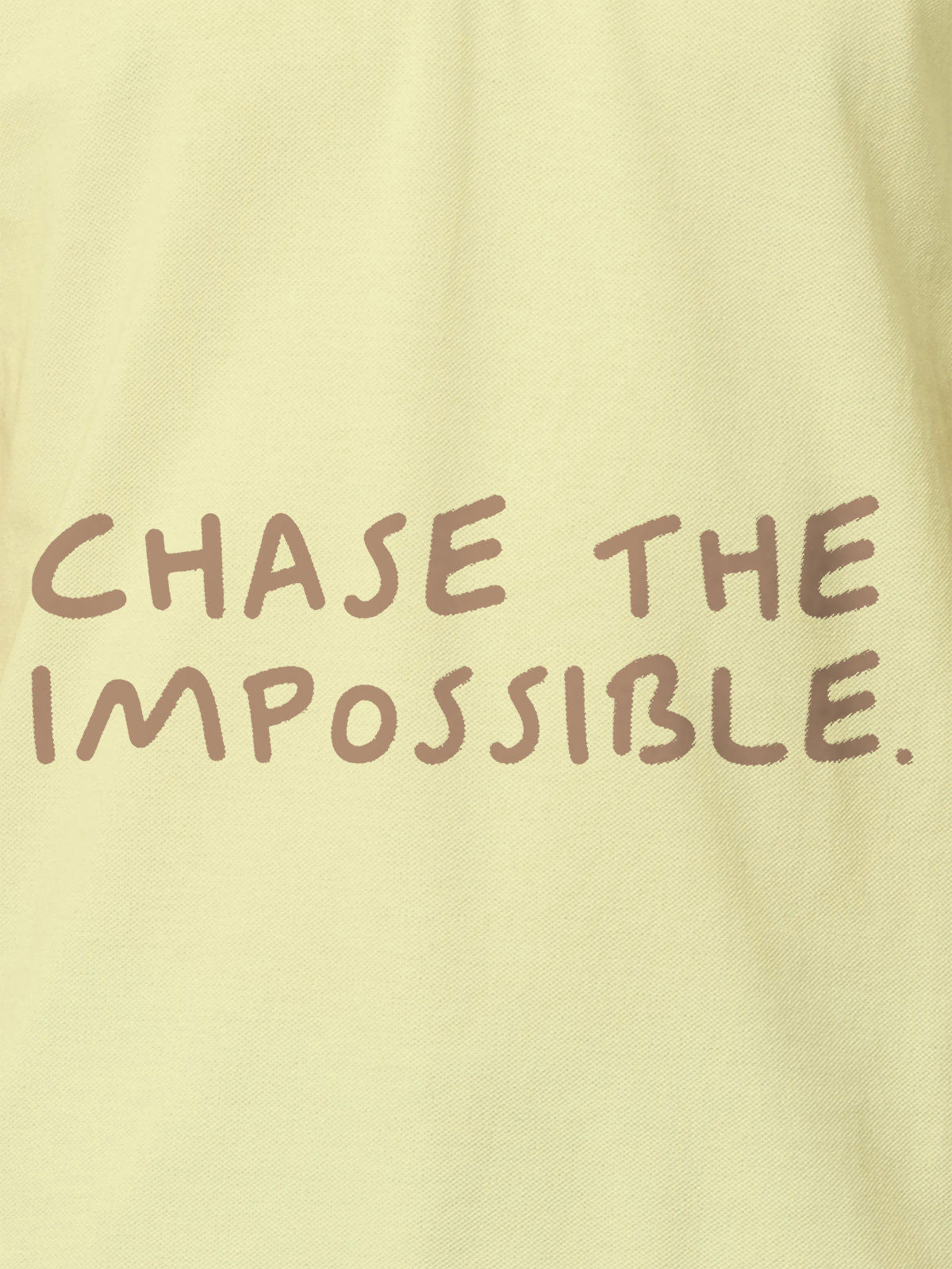 Close up of 'Chase The Impossible' design on Women's Yellow Polo T-shirt, highlighting intricate details and vibrant print.