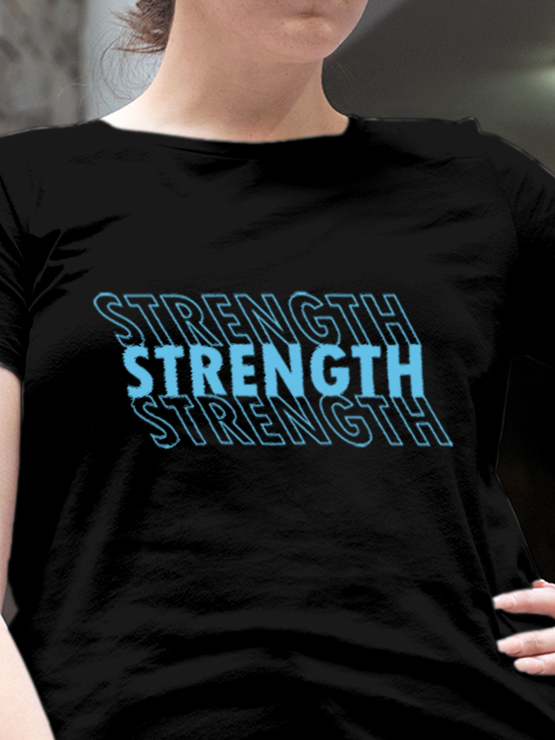 Close up of 'Strength' design on Women's Black Round Neck T-shirt, highlighting intricate details and vibrant print.
