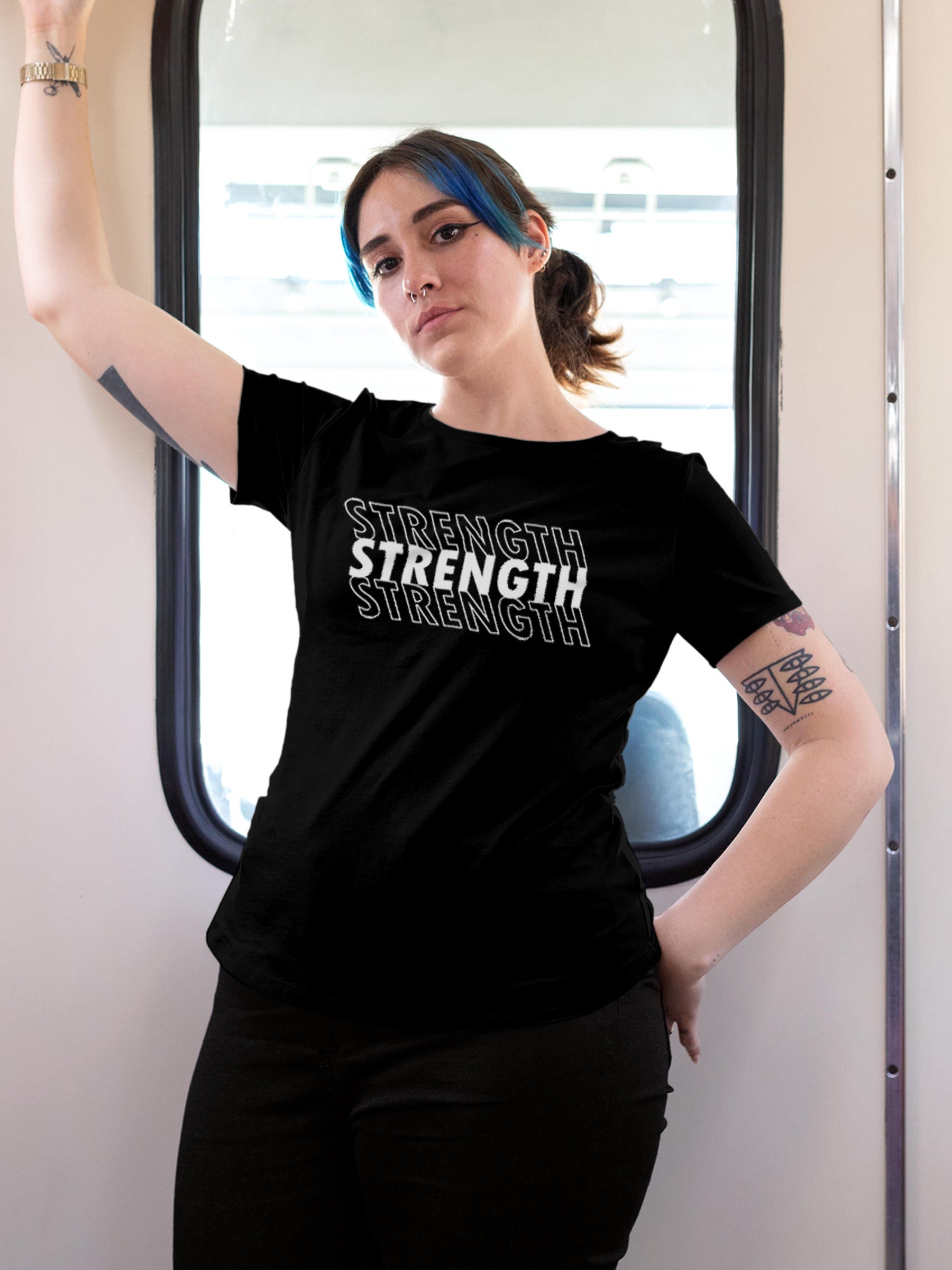 Model wearing Women's Black Round Neck T-shirt with 'Strength' design, offering effortless style and premium comfort