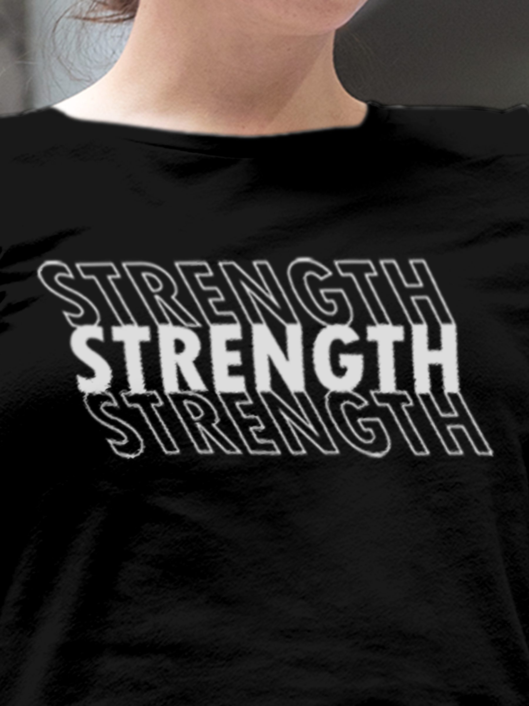 Close up of 'Strength' design on Women's Black Round Neck T-shirt, highlighting intricate details and vibrant print.