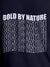 Close up of 'Bold By Nature' design on Men's Navy Blue Round Neck T-shirt, highlighting intricate details and vibrant print.